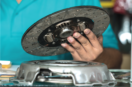 A person is holding a clutch disc in their hands.