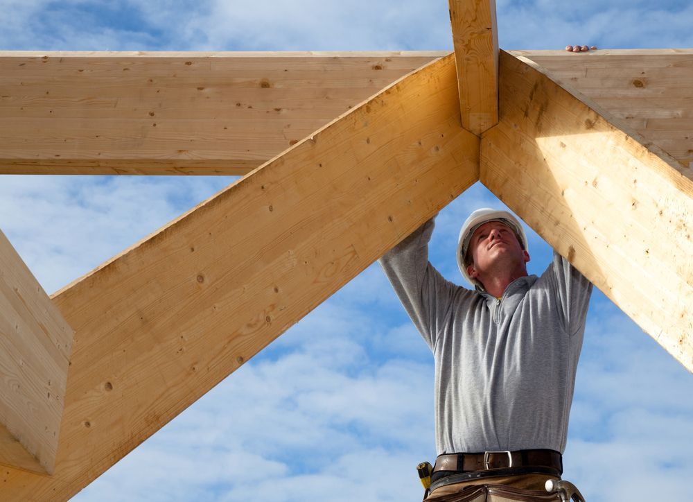 Carpenter Working on Wooden Framework Against a Blue Sky — Lunny's Carpentry In Caloundra, QLD
