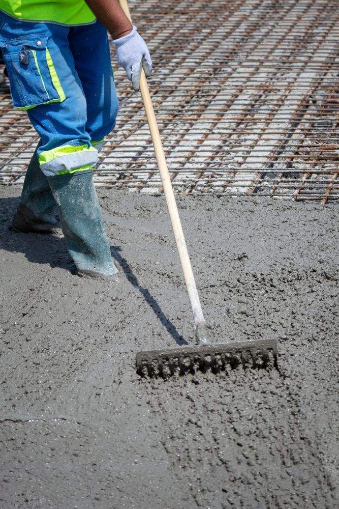 Construction Worker Raking Wet Concrete on A Surface — Lunny's Carpentry In Caloundra, QLD