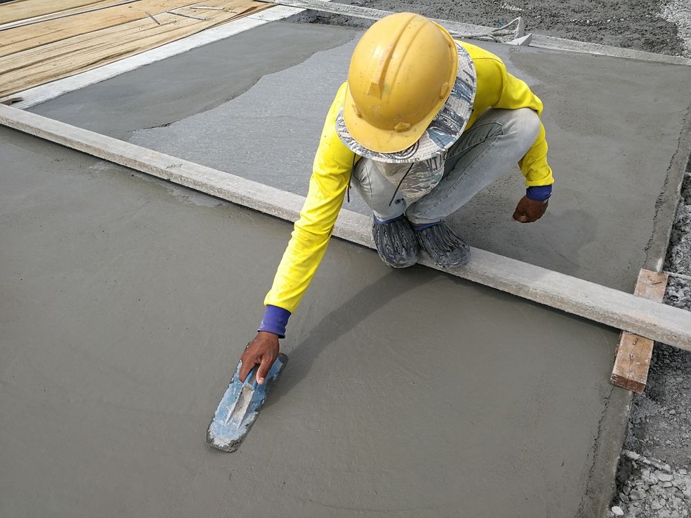 Construction Worker Smoothing Fresh Concrete with A Trowel — Lunny's Carpentry In Caloundra, QLD