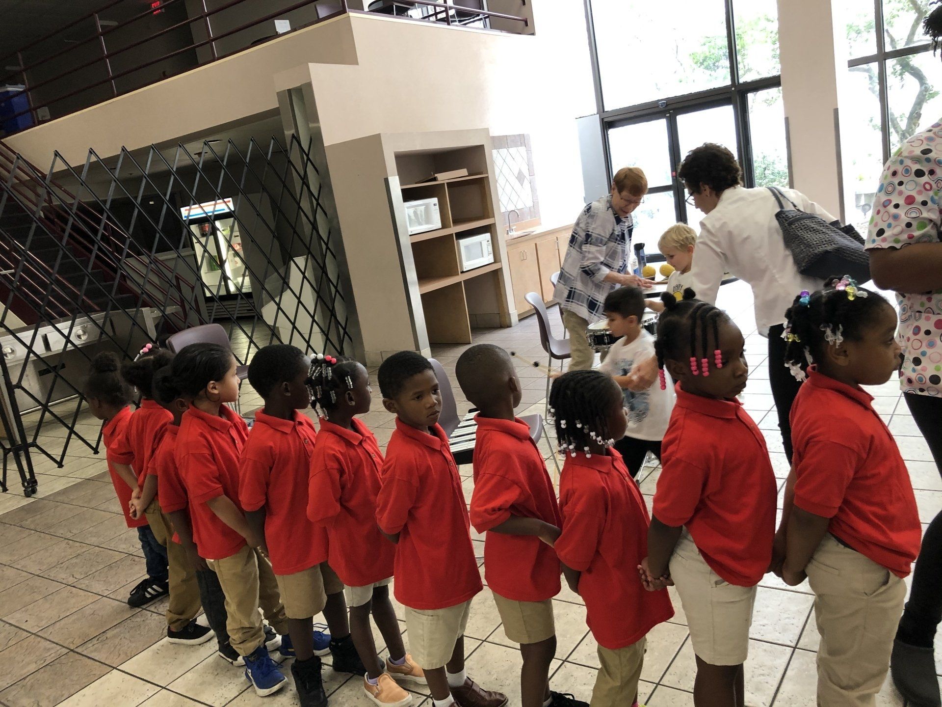 A group of children in red shirts are standing in a line.