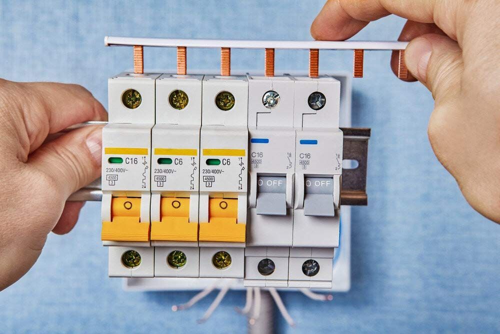 A Person Is Holding A Bunch Of Electrical Switches In Their Hands — IPOWER Industries In Bowen, QLD