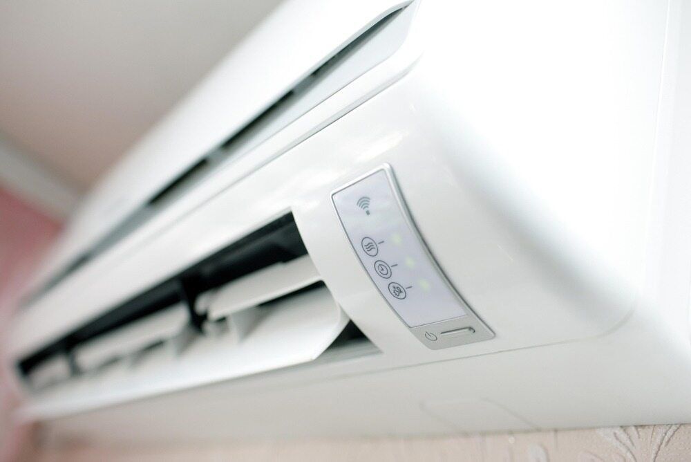 A White Air Conditioner Is Hanging On A Wall — IPOWER Industries In Airlie Beach, QLD
