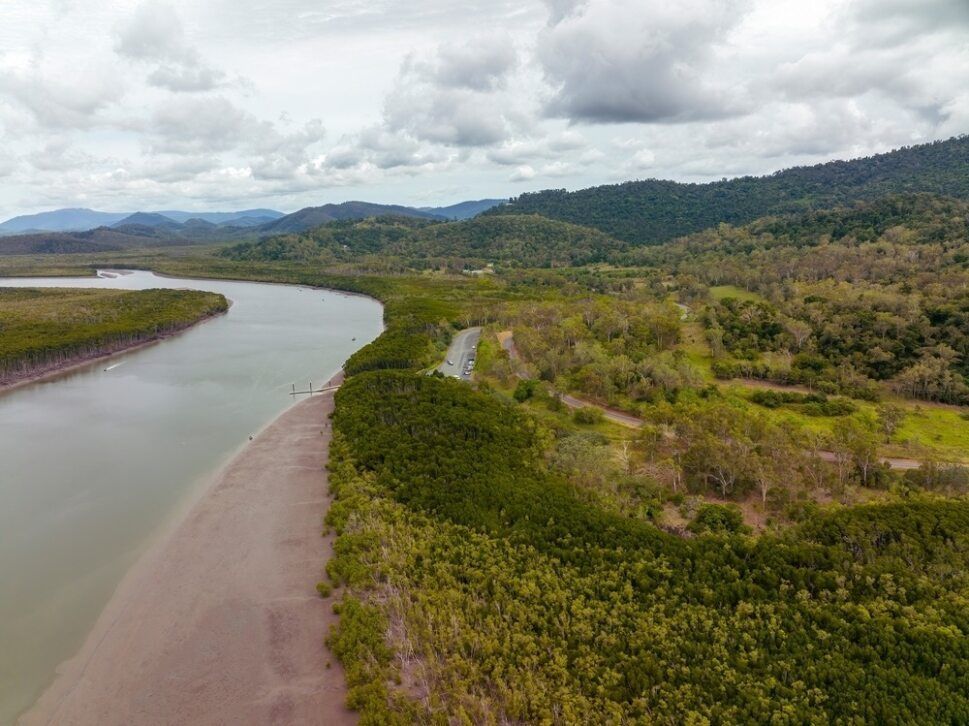 An Aerial View Of A River Surrounded By Trees And Mountains — IPOWER Industries In Proserpine, QLD