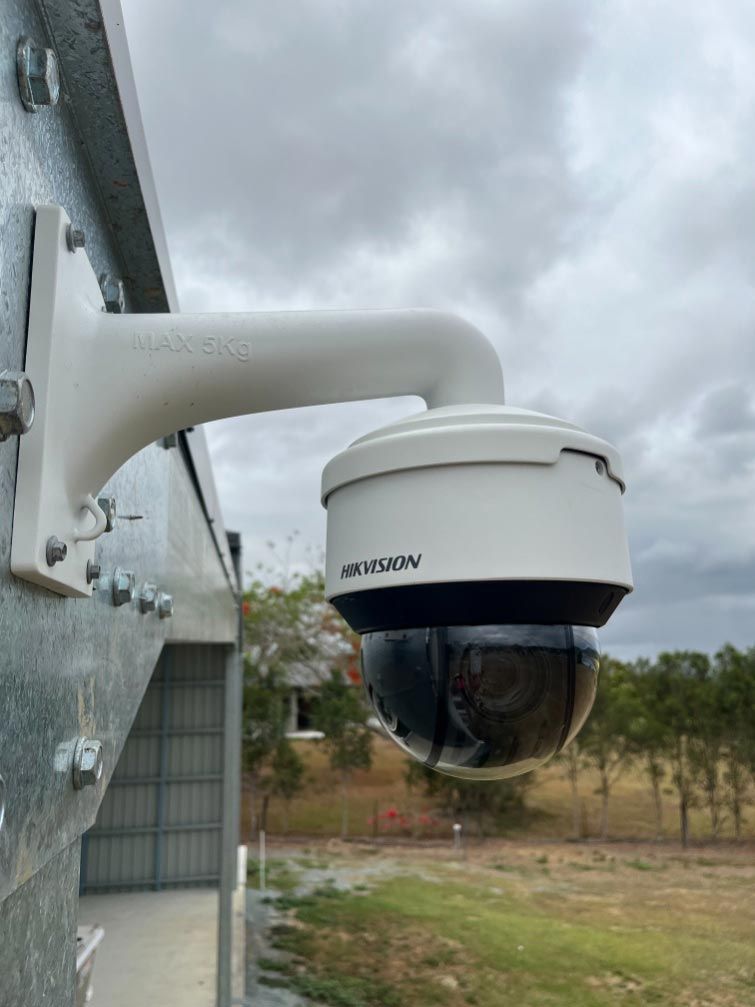 A Security Camera Is Mounted On The Side Of A Building — IPOWER Industries In Cannonvale, QLD