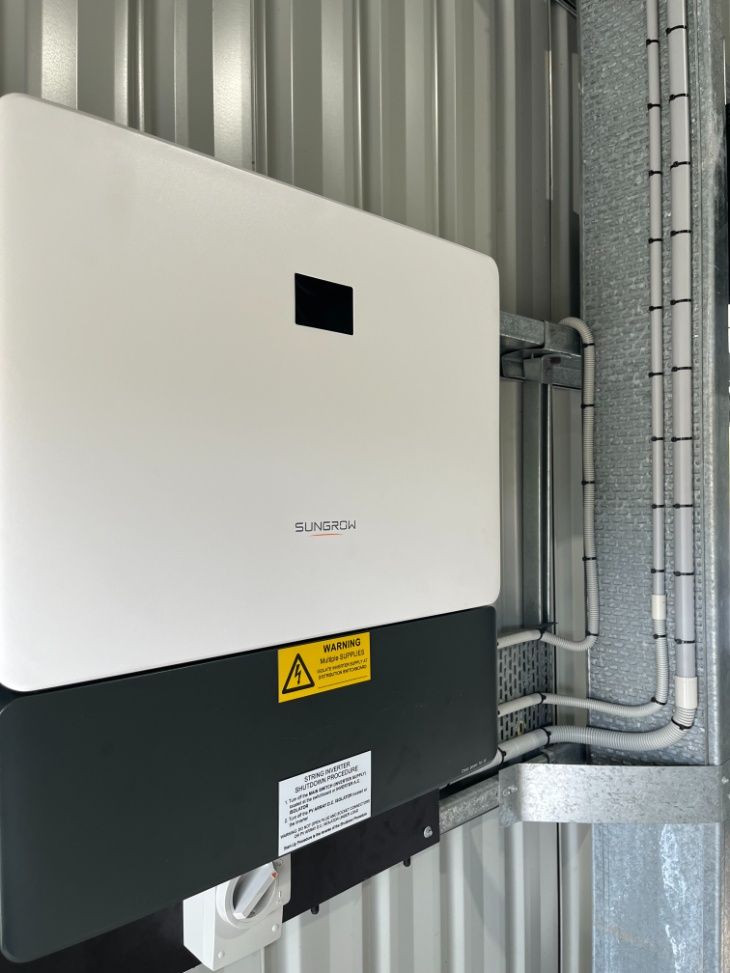 A White And Black Box Is Hanging On A Metal Wall — IPOWER Industries In Strathdickie, QLD