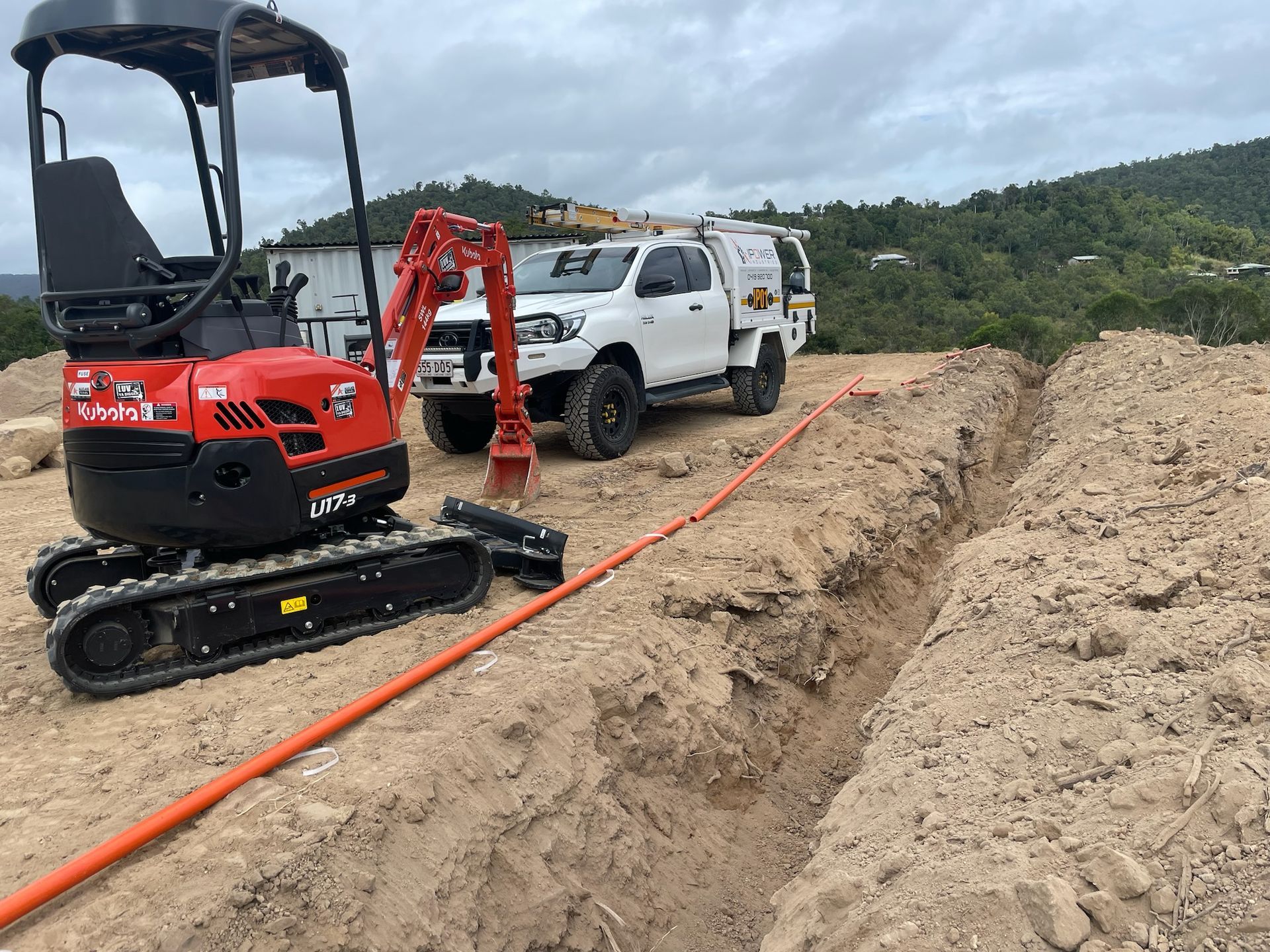 A Digger Sitting Next To A Truck With Cables— IPOWER Industries In Strathdickie, QLD