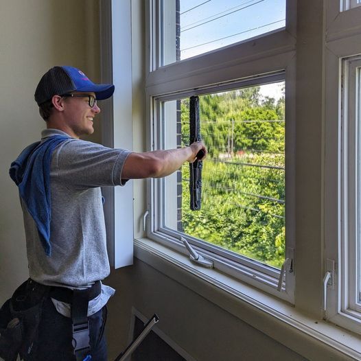 G&S employee using squeegee to clean a window