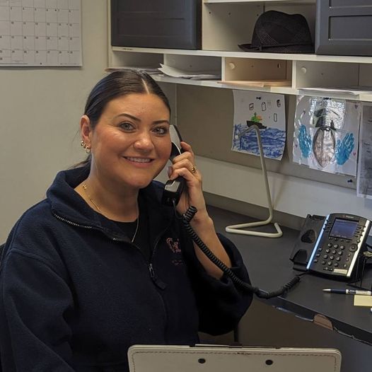 A woman sitting at a desk talking on a phone