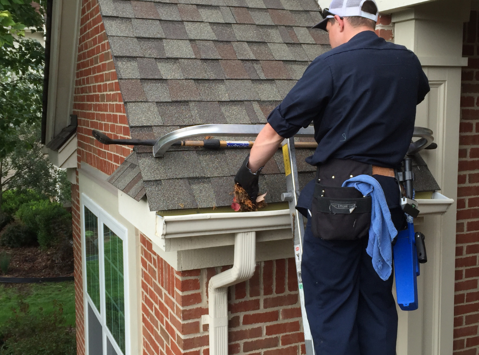 G&S employee removing dirt and debris from a gutter