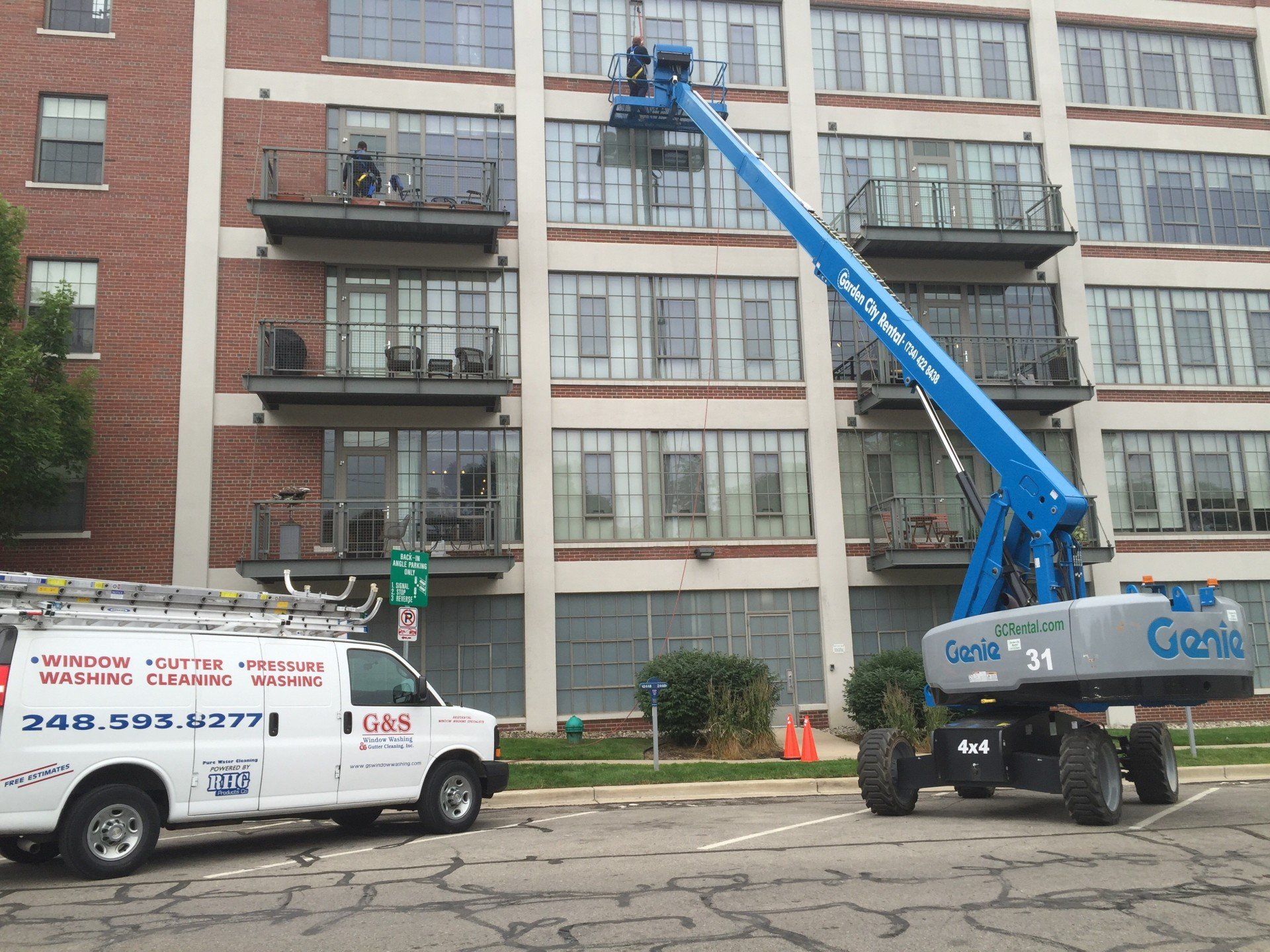 A genie truck is parked in front of a building
