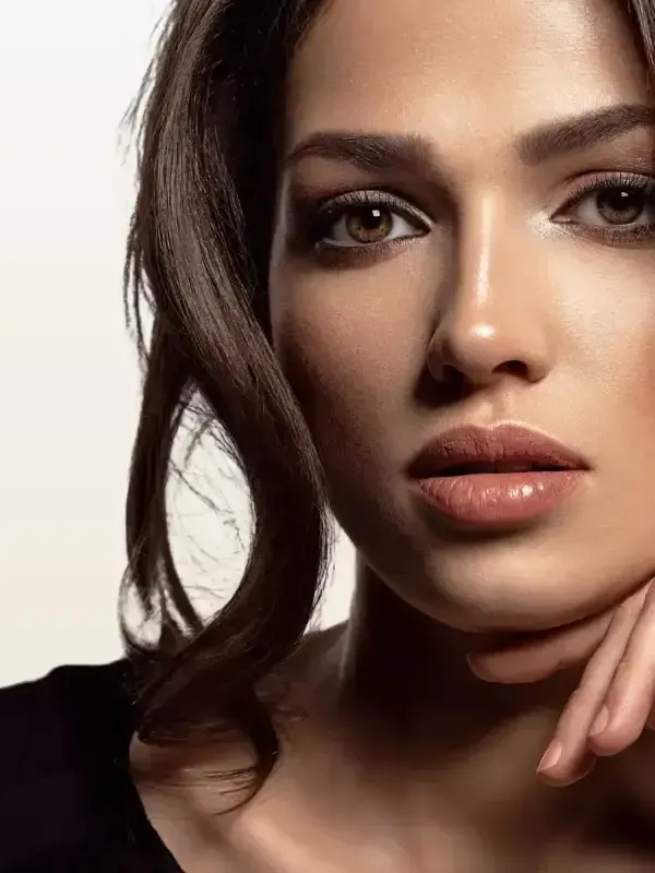 A close up of a woman 's face with her hand on her chin.