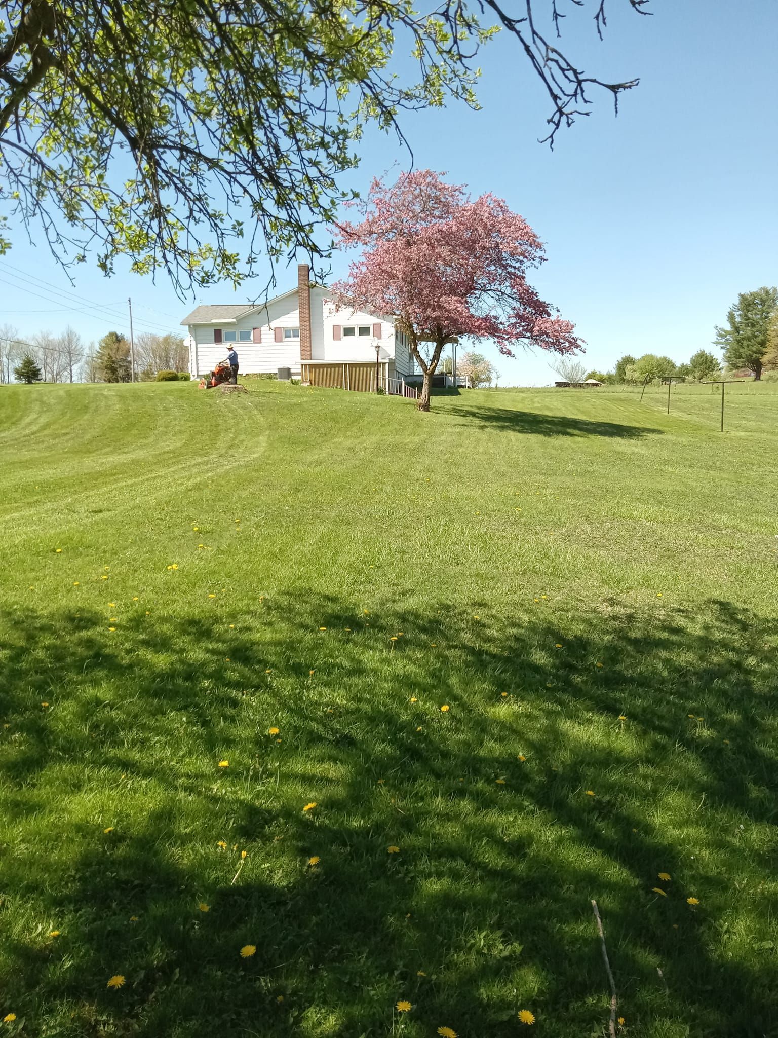 A white house is sitting on top of a grassy hill.
