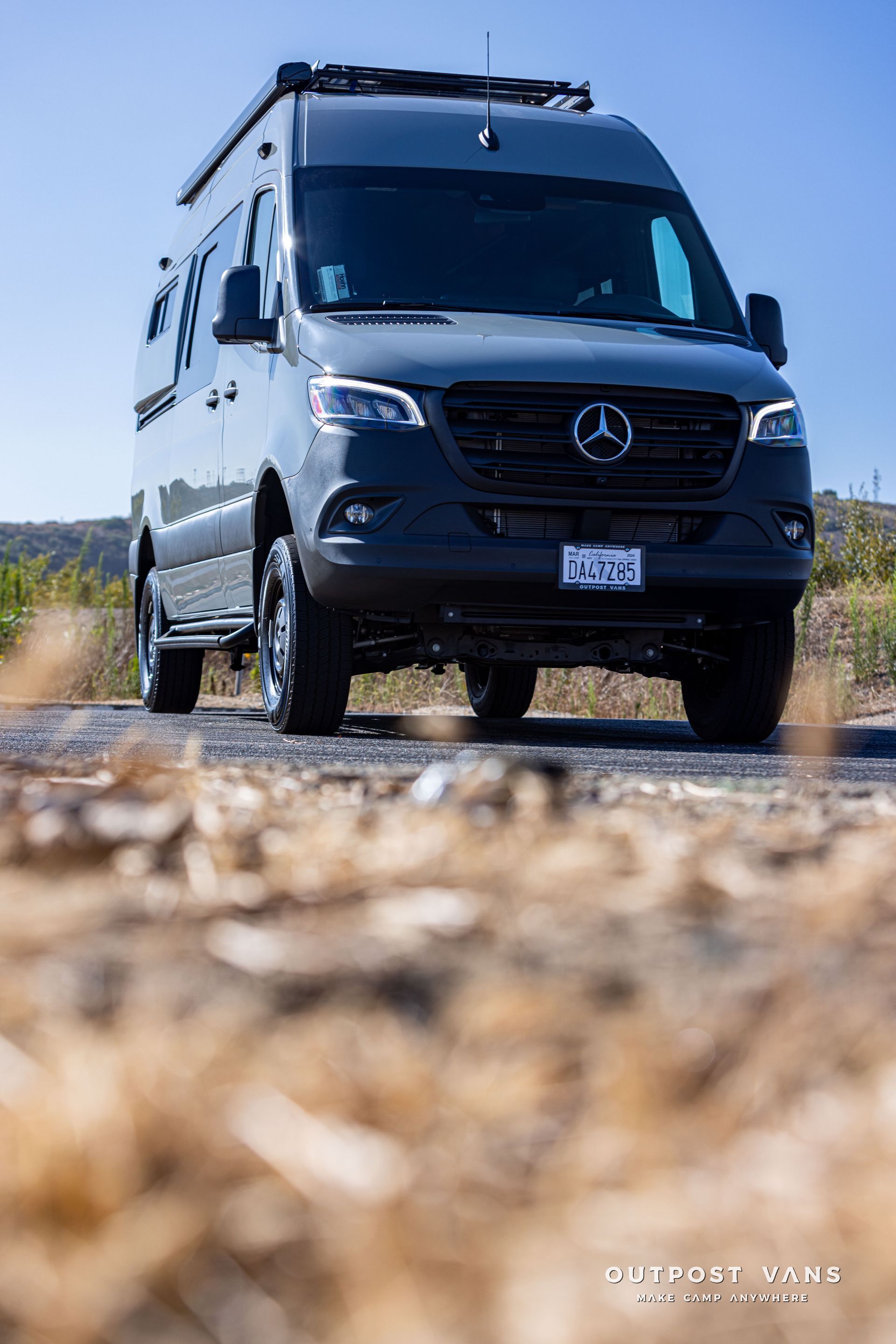 A mercedes sprinter van is parked on the side of a road.