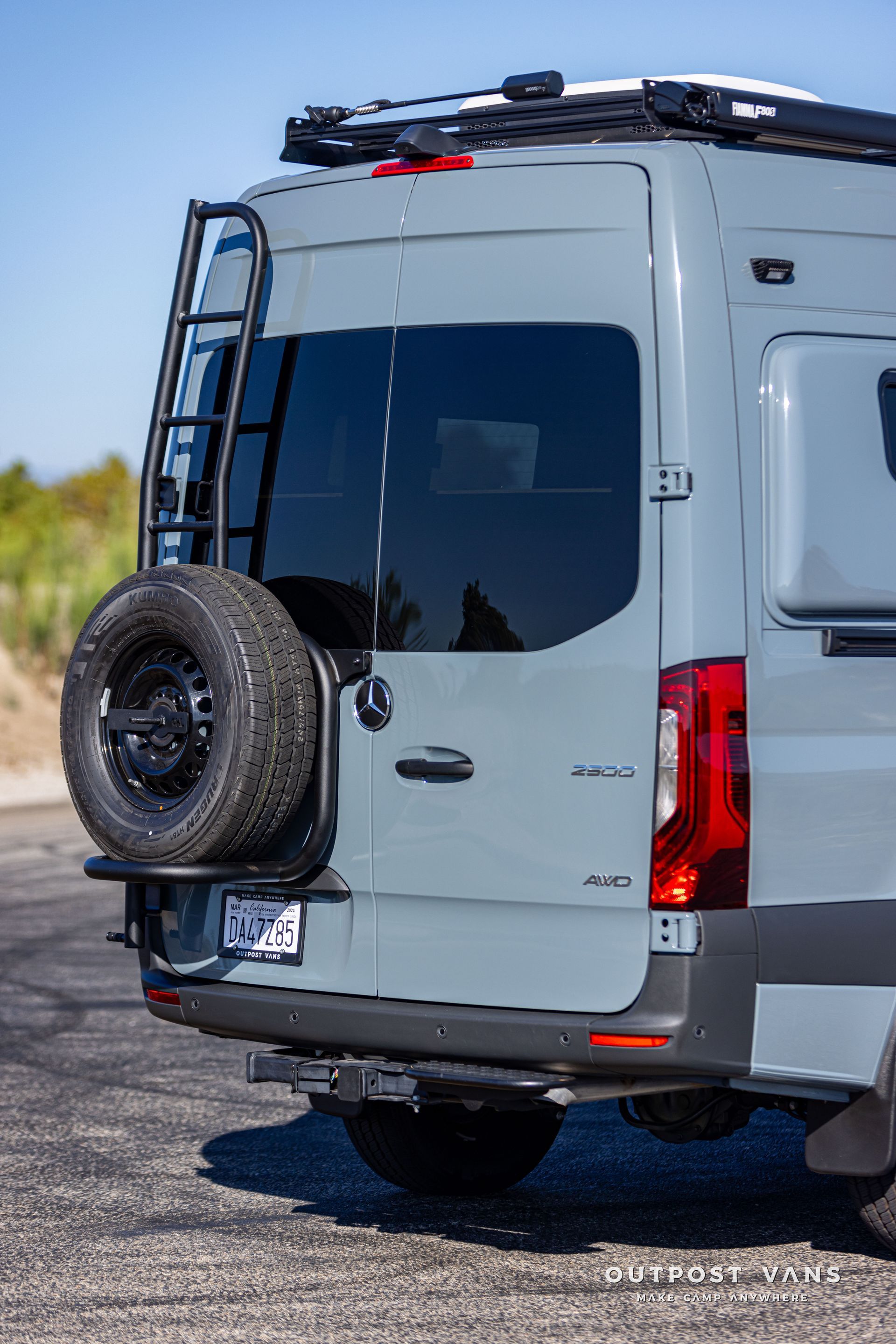 The back of a van with a spare tire on the back of it.