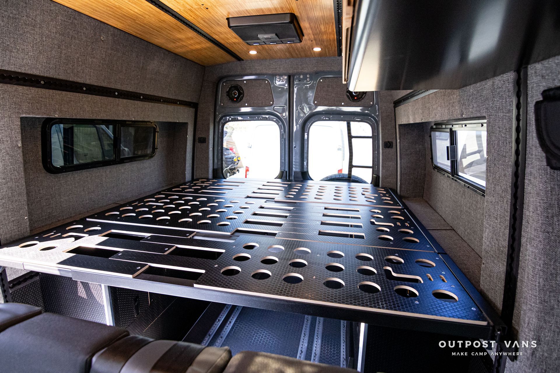 The inside of a van with a bed in the back.
