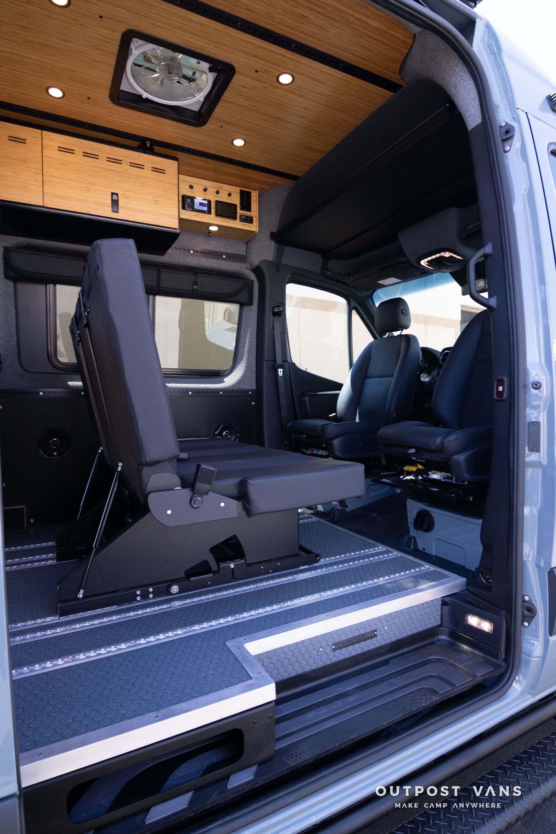 The inside of a van with the door open and the seats folded down.