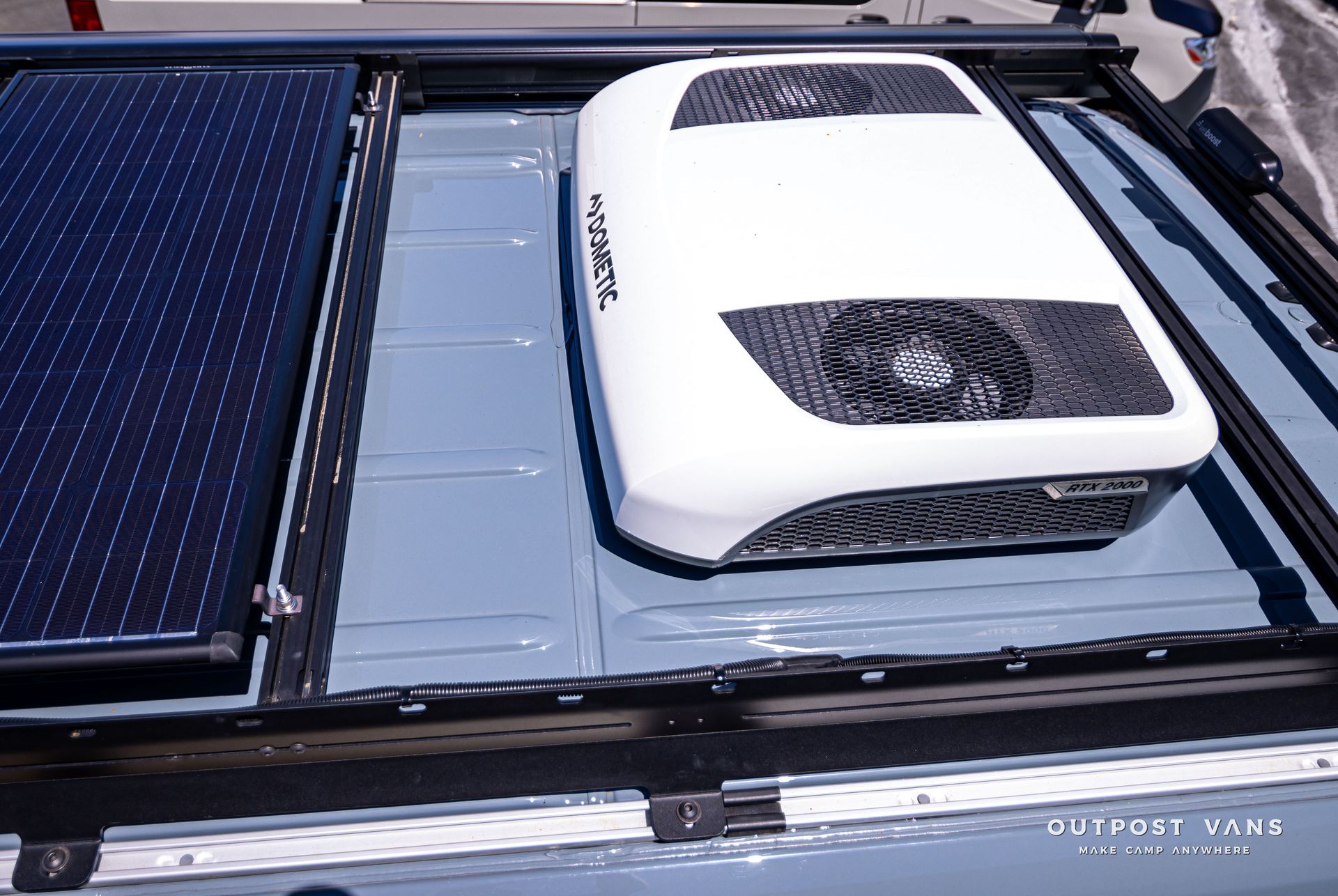 A roof mounted air conditioner with a solar panel attached to it