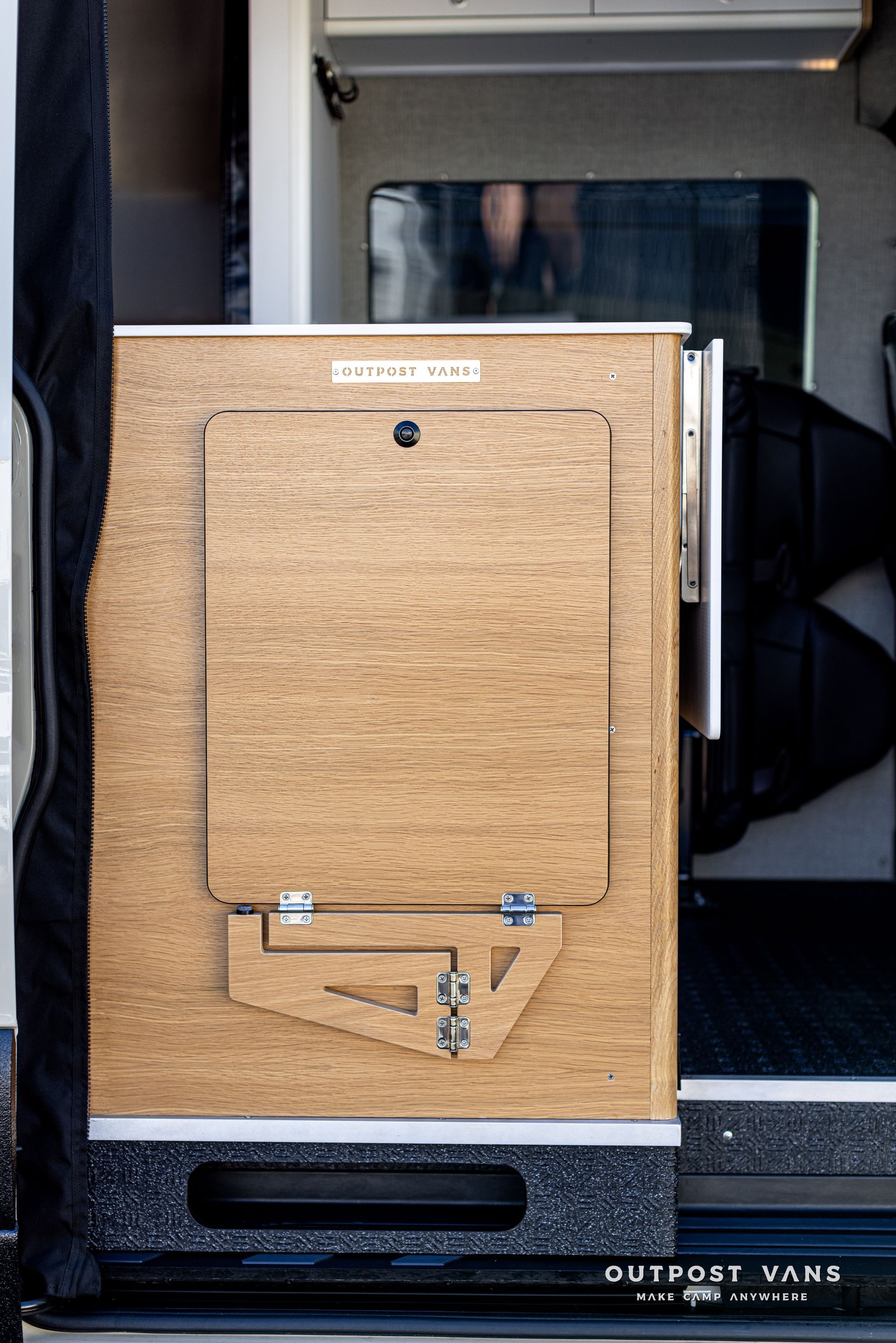 A wooden box is sitting in the back of a van.