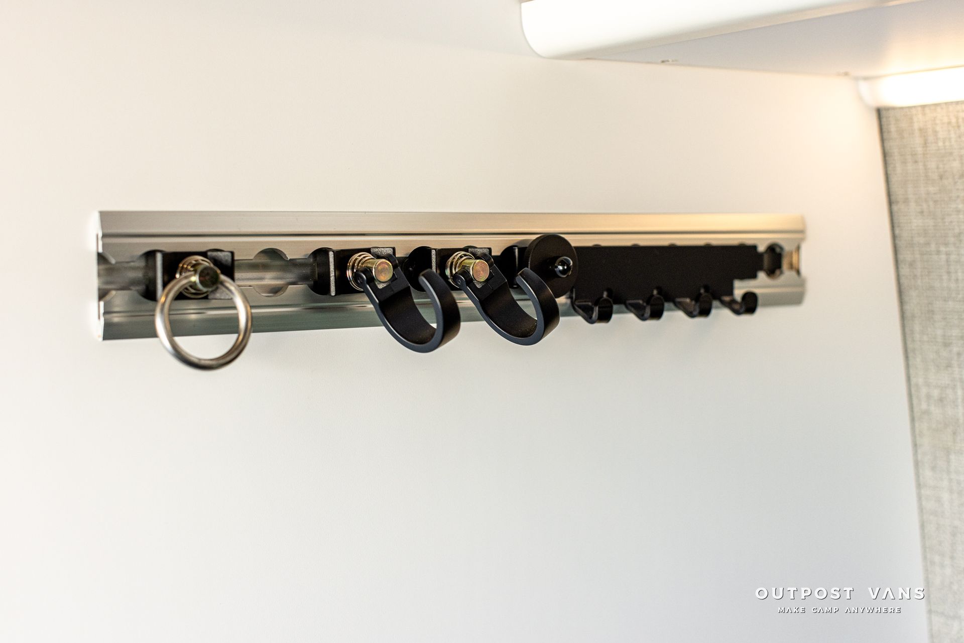 A row of hooks hanging on a white wall.