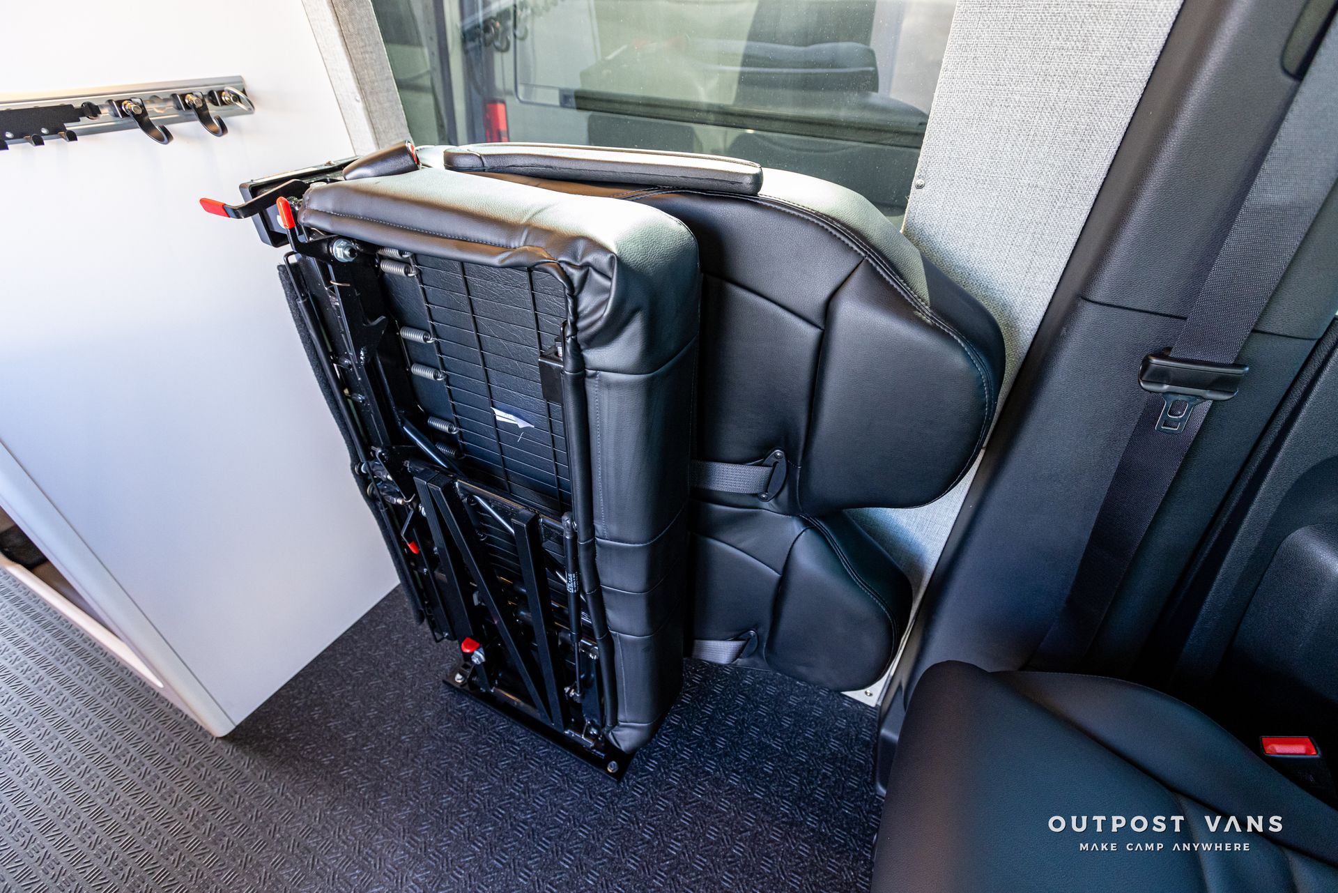 A car seat is folded up in the back seat of a van.