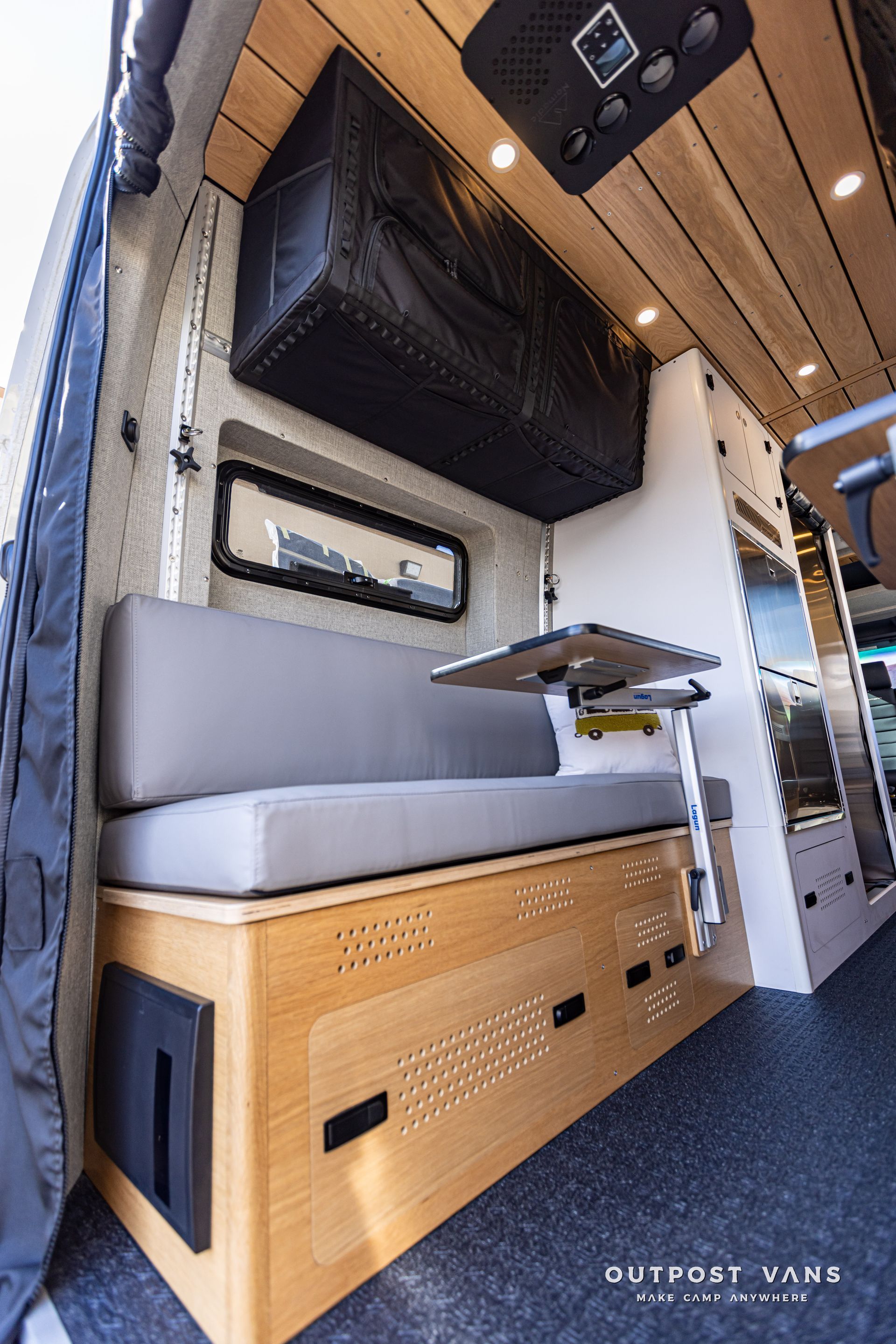 The inside of a van with a couch and a table.