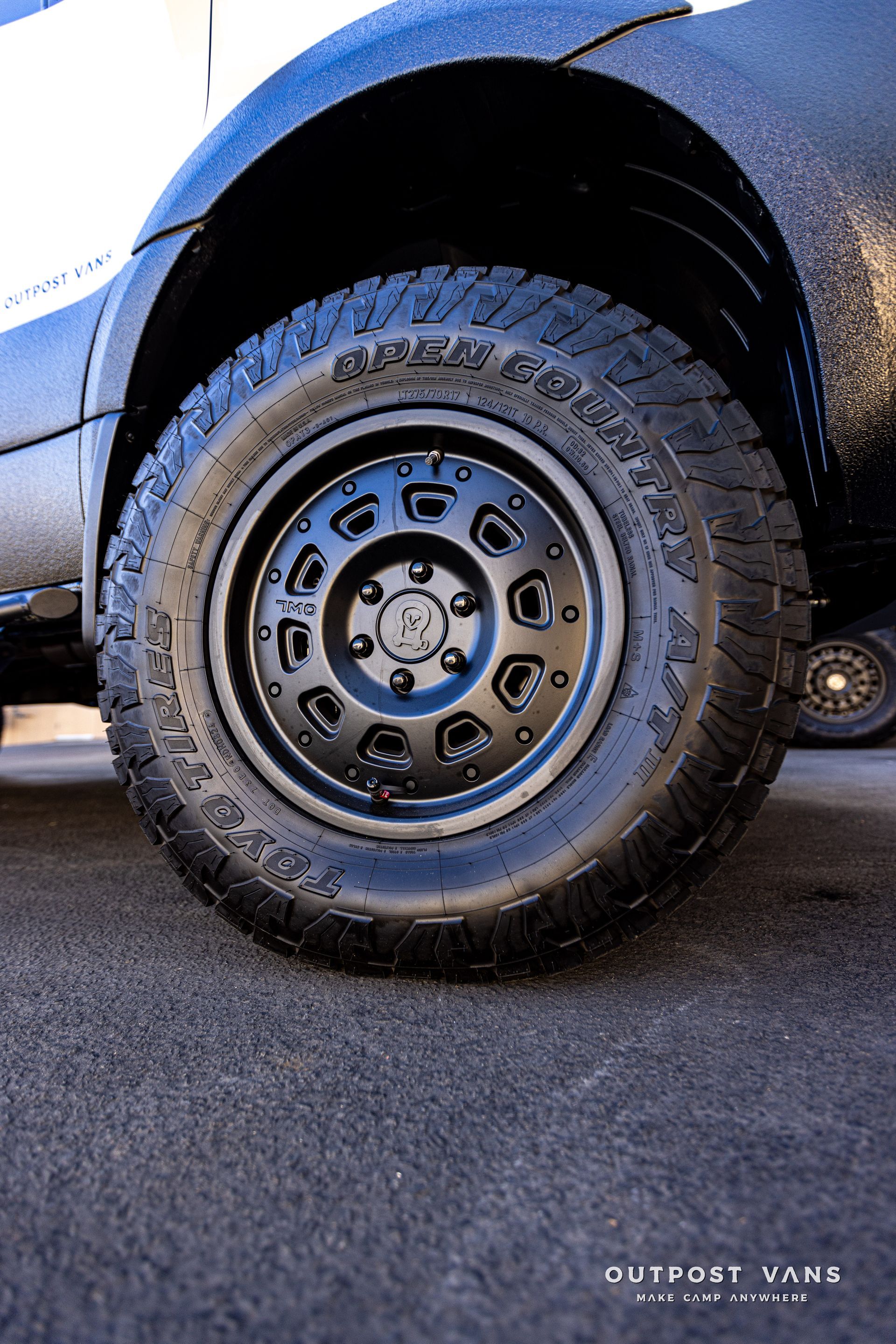 A close up of a black tire on a black truck.