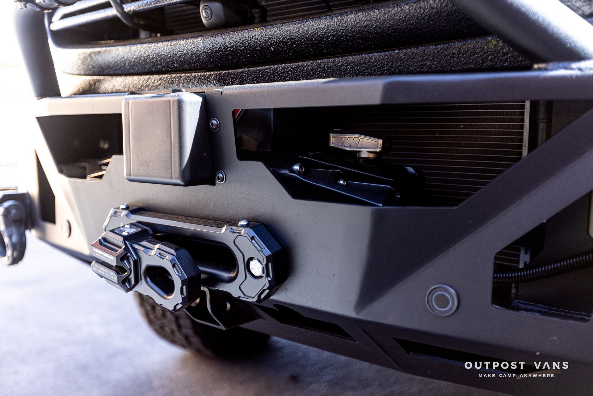 A close up of the front bumper of a truck with a winch attached to it.