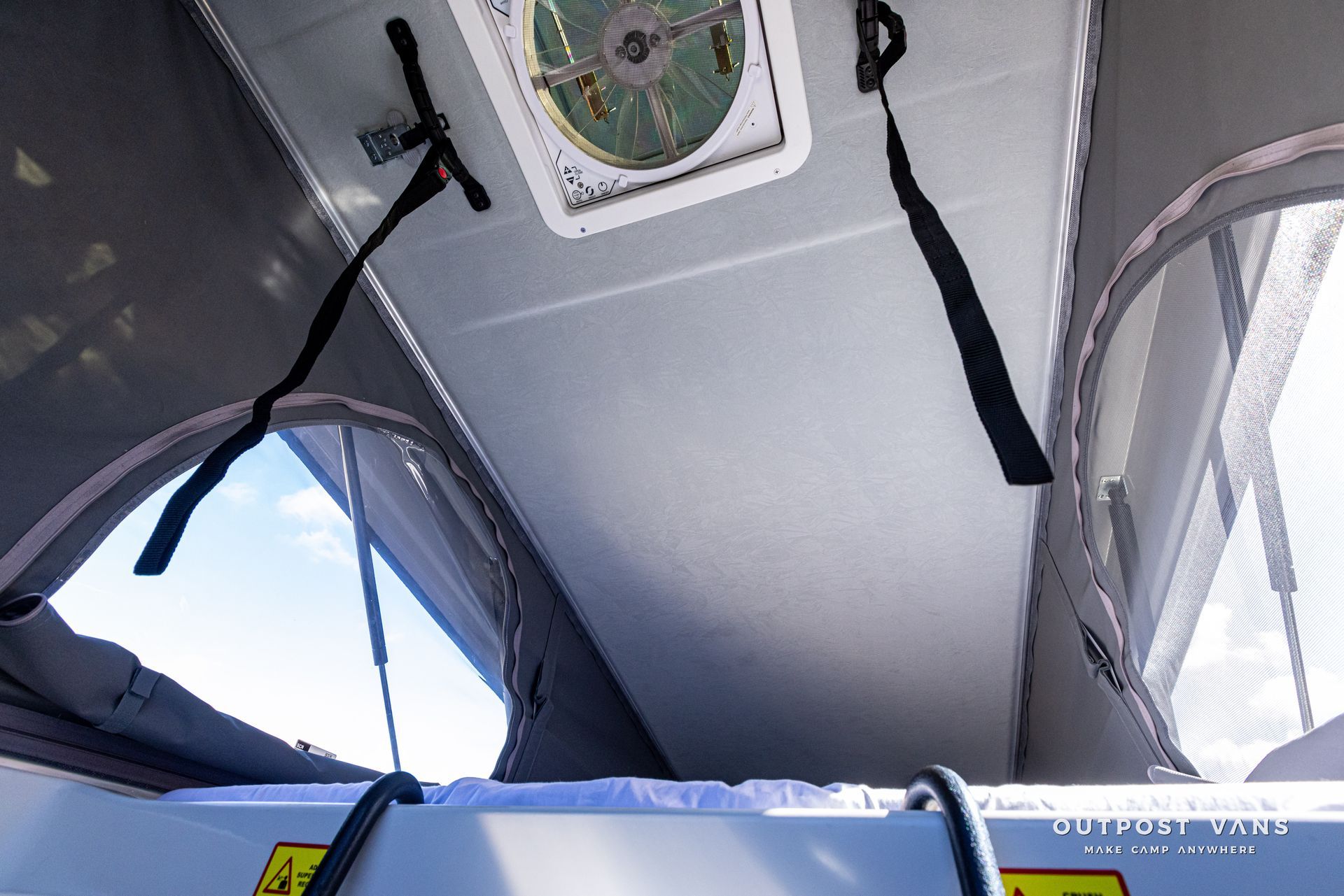 Looking up at the ceiling of a tent with a fan on it