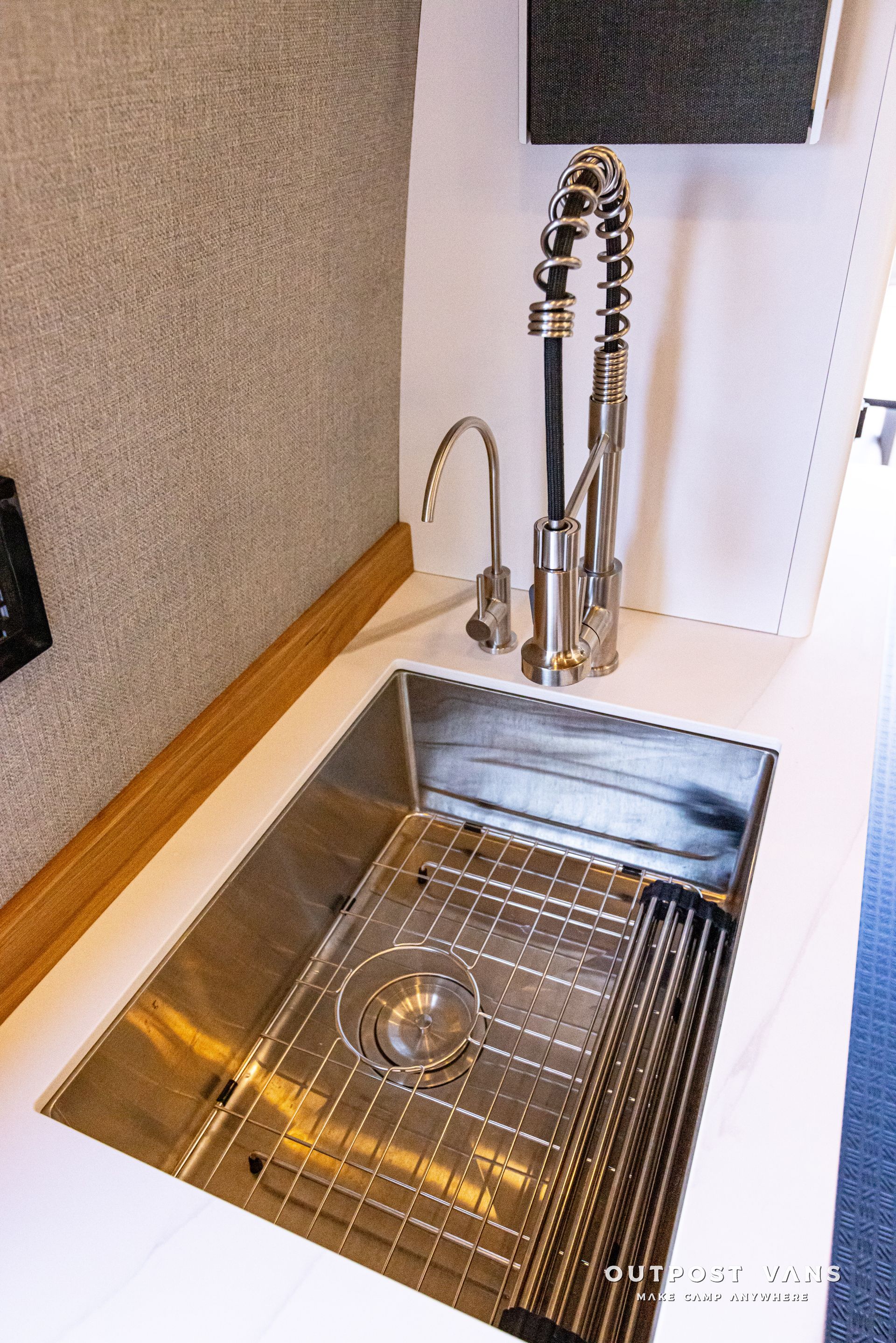A stainless steel sink with a faucet in a kitchen.