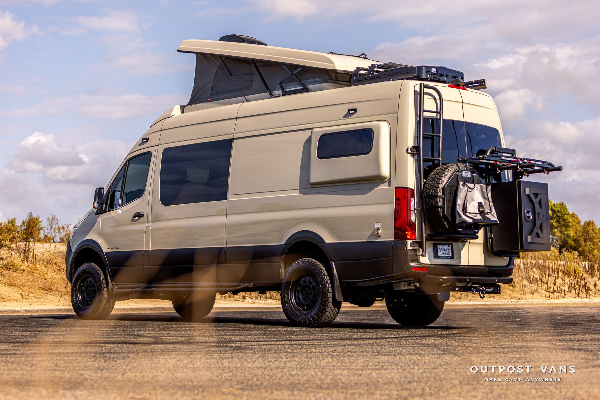 A white van with a pop top roof is parked on the side of the road.