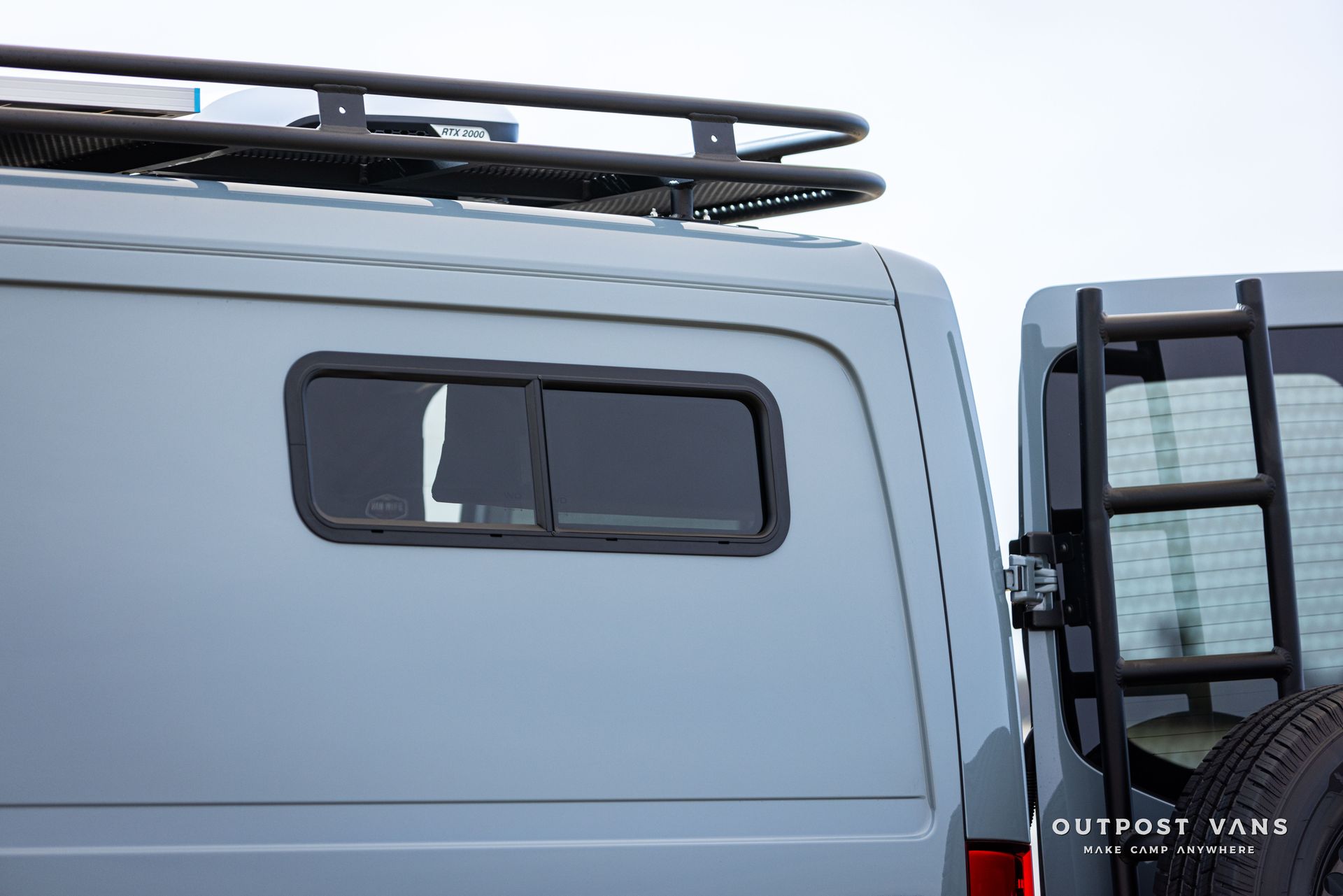 A van with a ladder on the back of it and a roof rack.