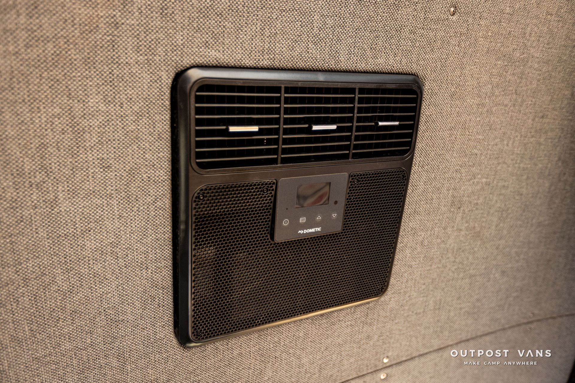 A close up of a wall mounted air conditioner on a wall.