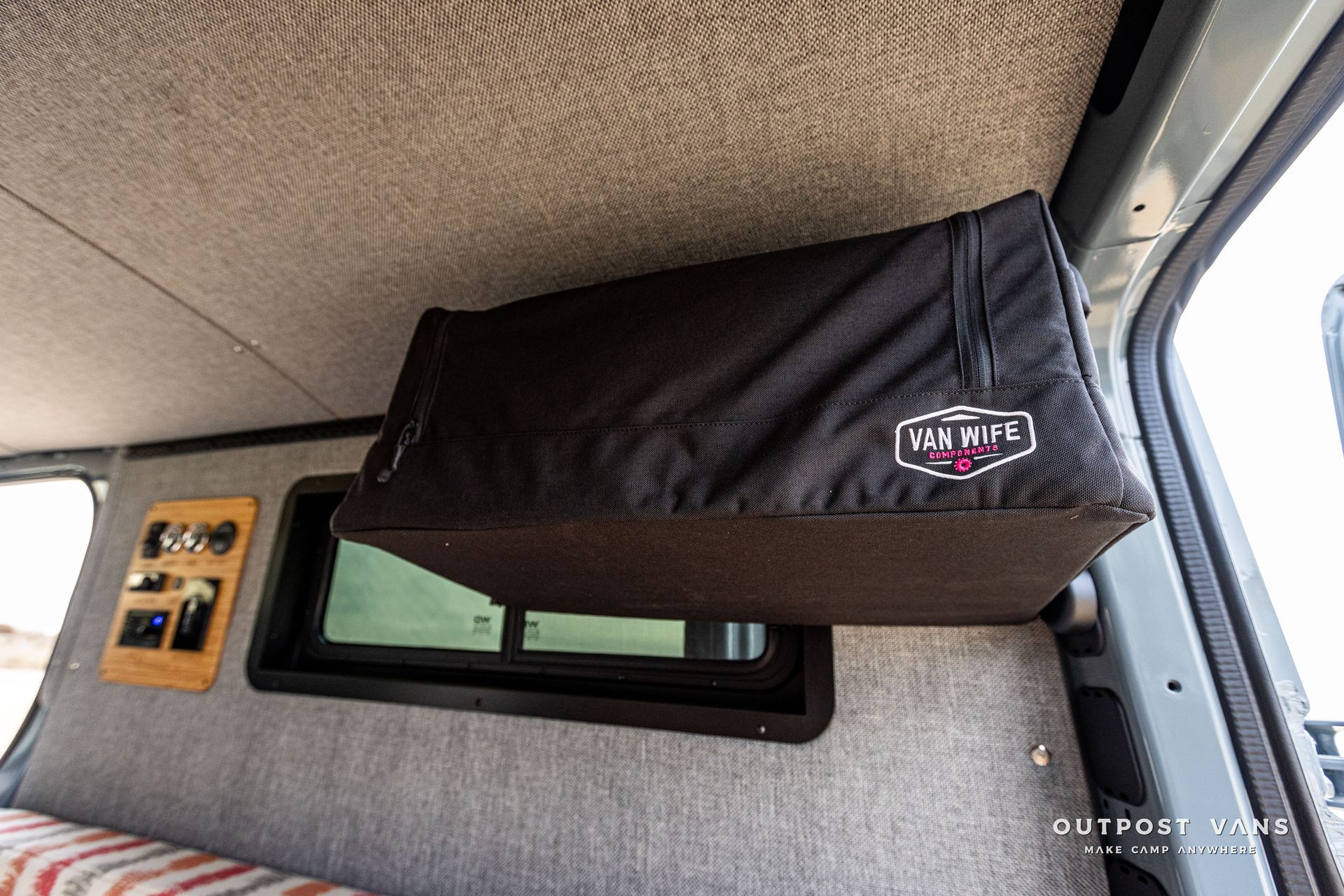 A black bag is hanging from the ceiling of a van.