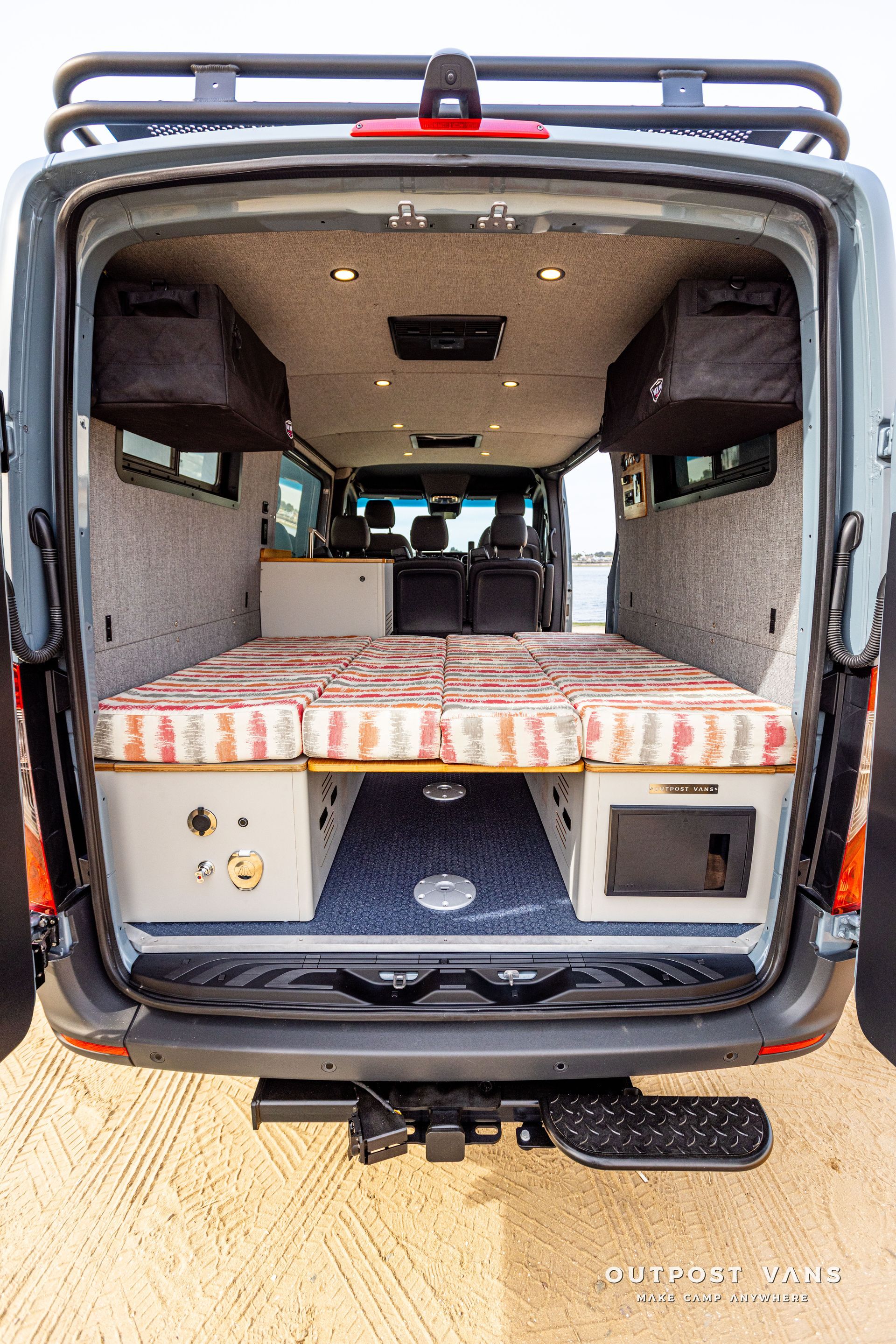 The back of a van with a bed in it.
