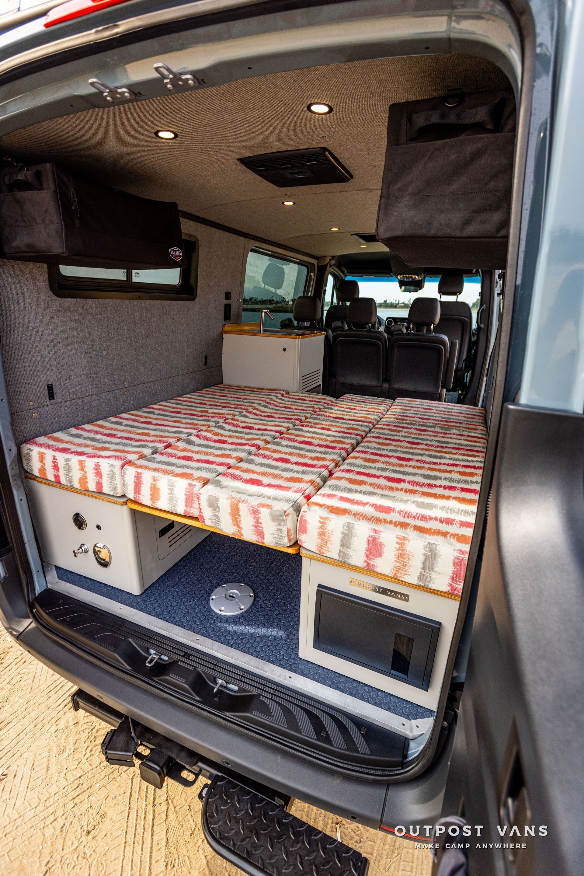 The back of a van with a bed in it.