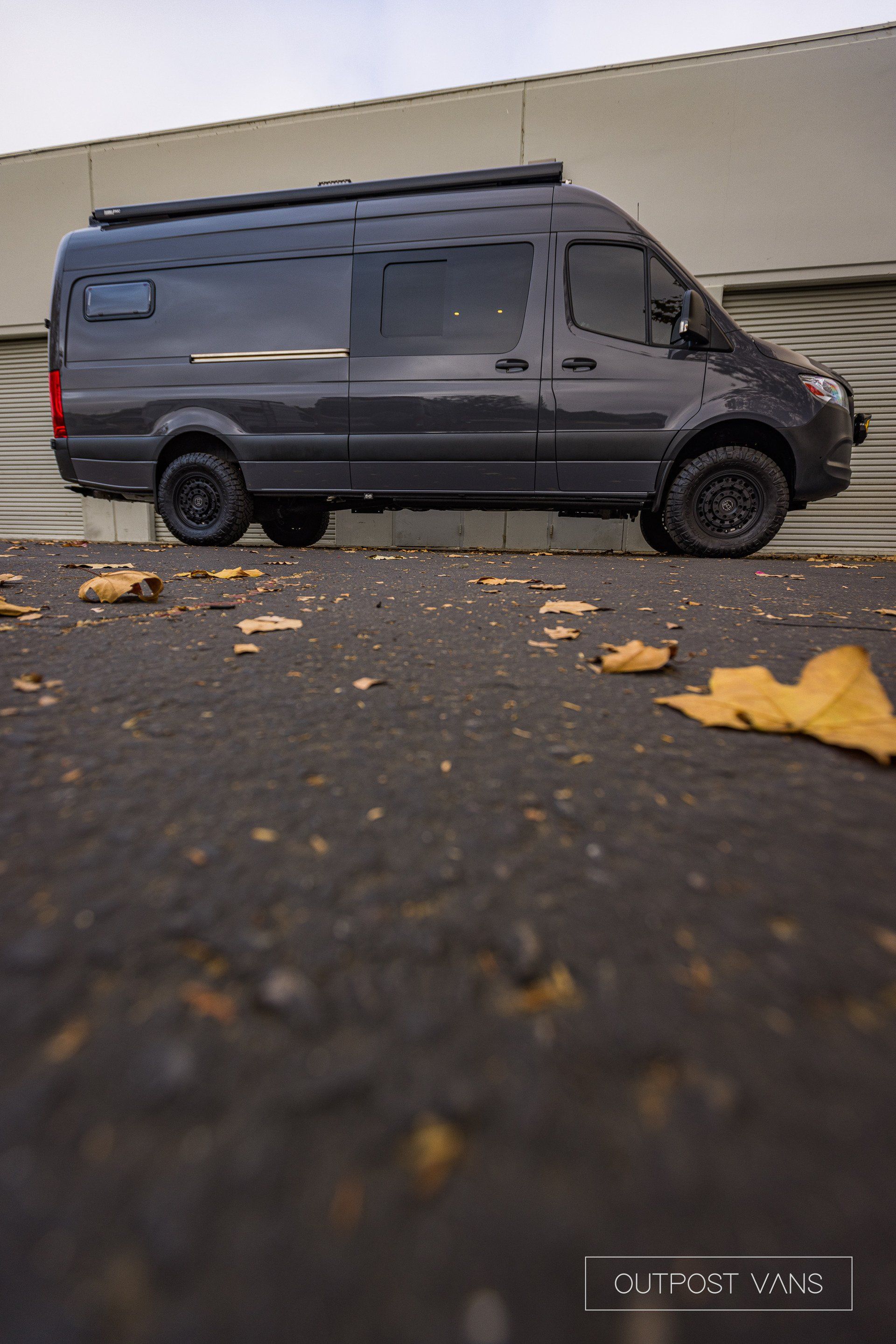 a black van is parked in front of a building .