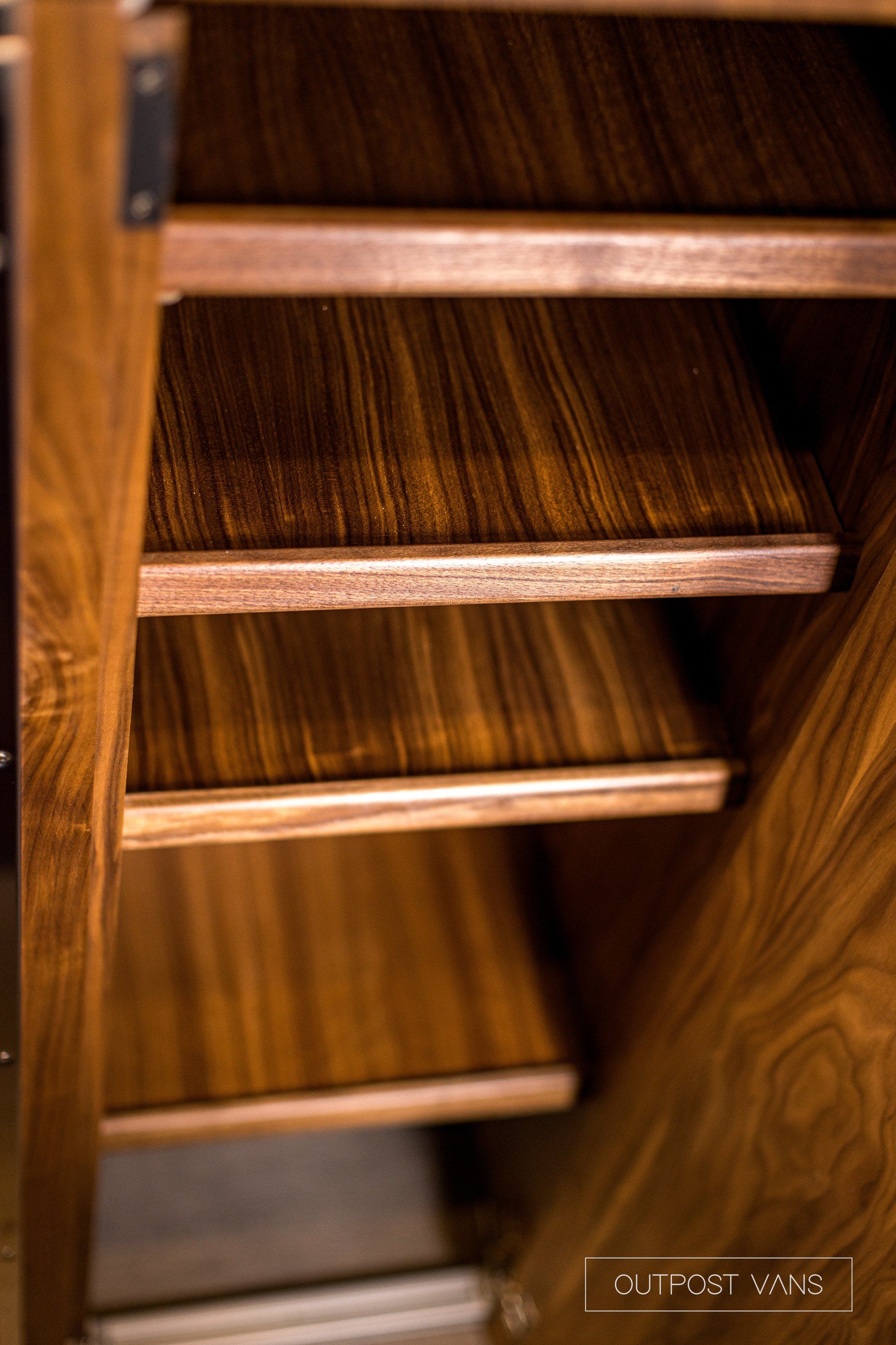 A close up of a wooden shelf in a cabinet.