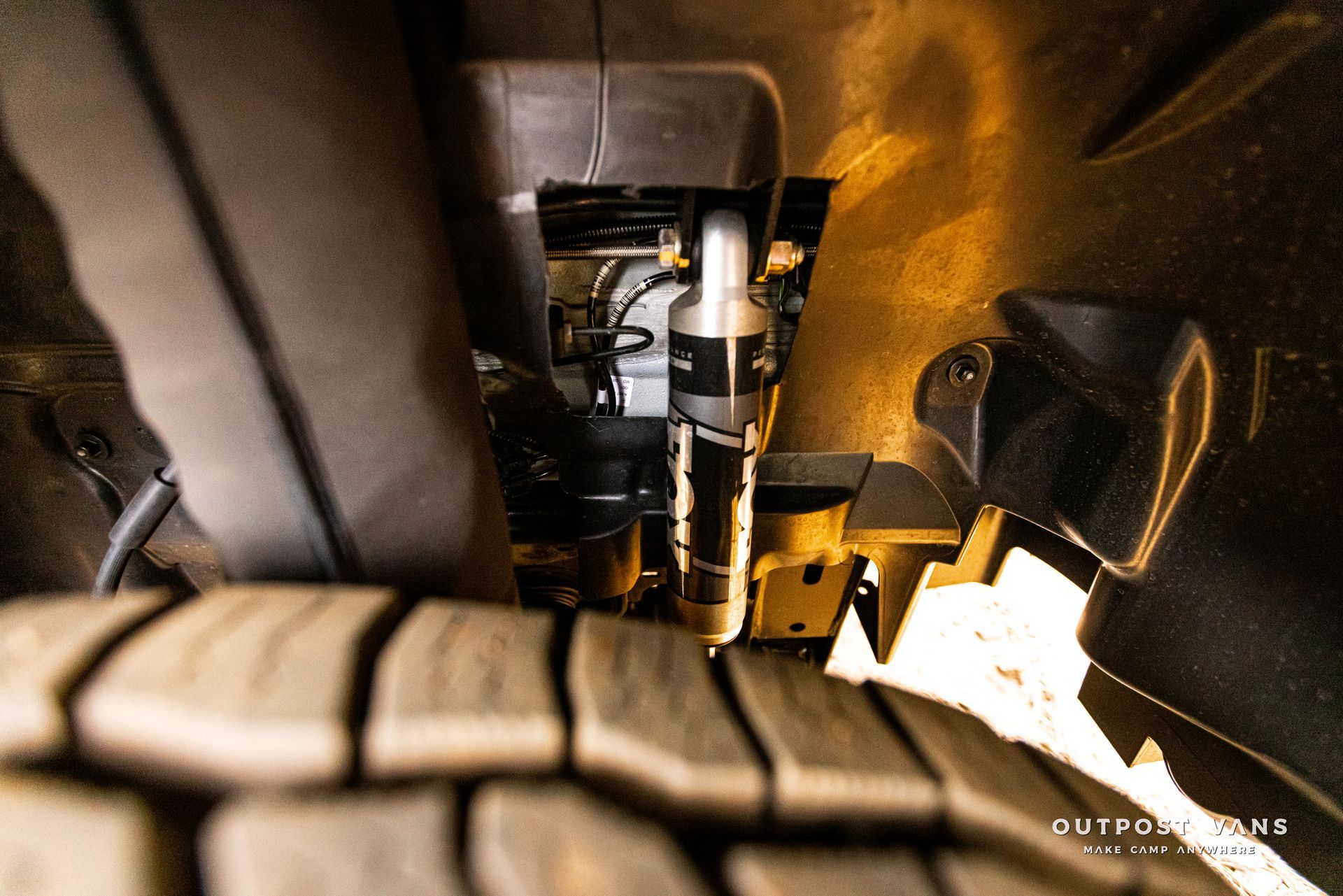 A close up of a tire on a car with a hose attached to it.