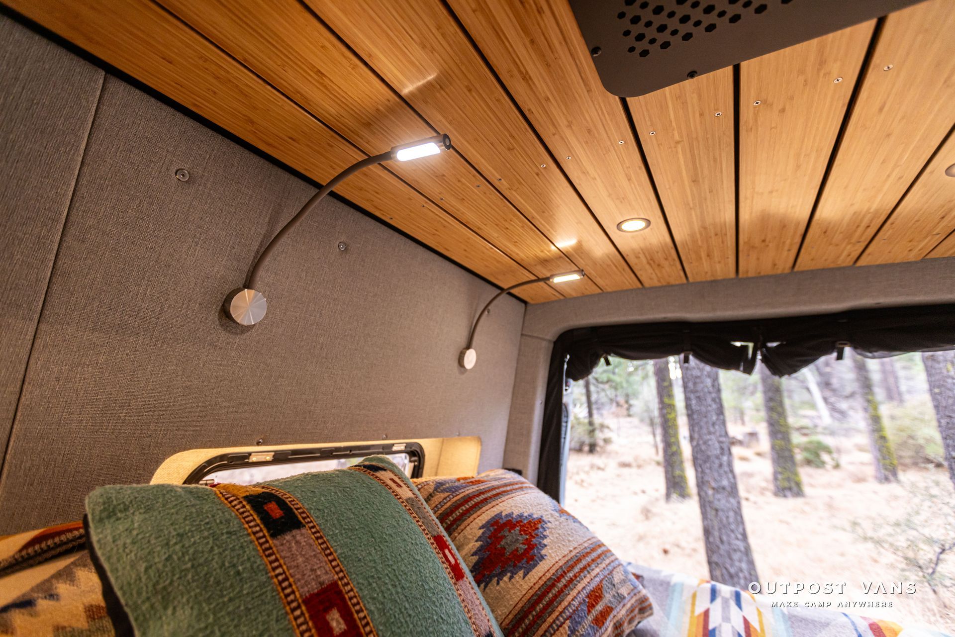 A camper van with a wooden ceiling and a bed.