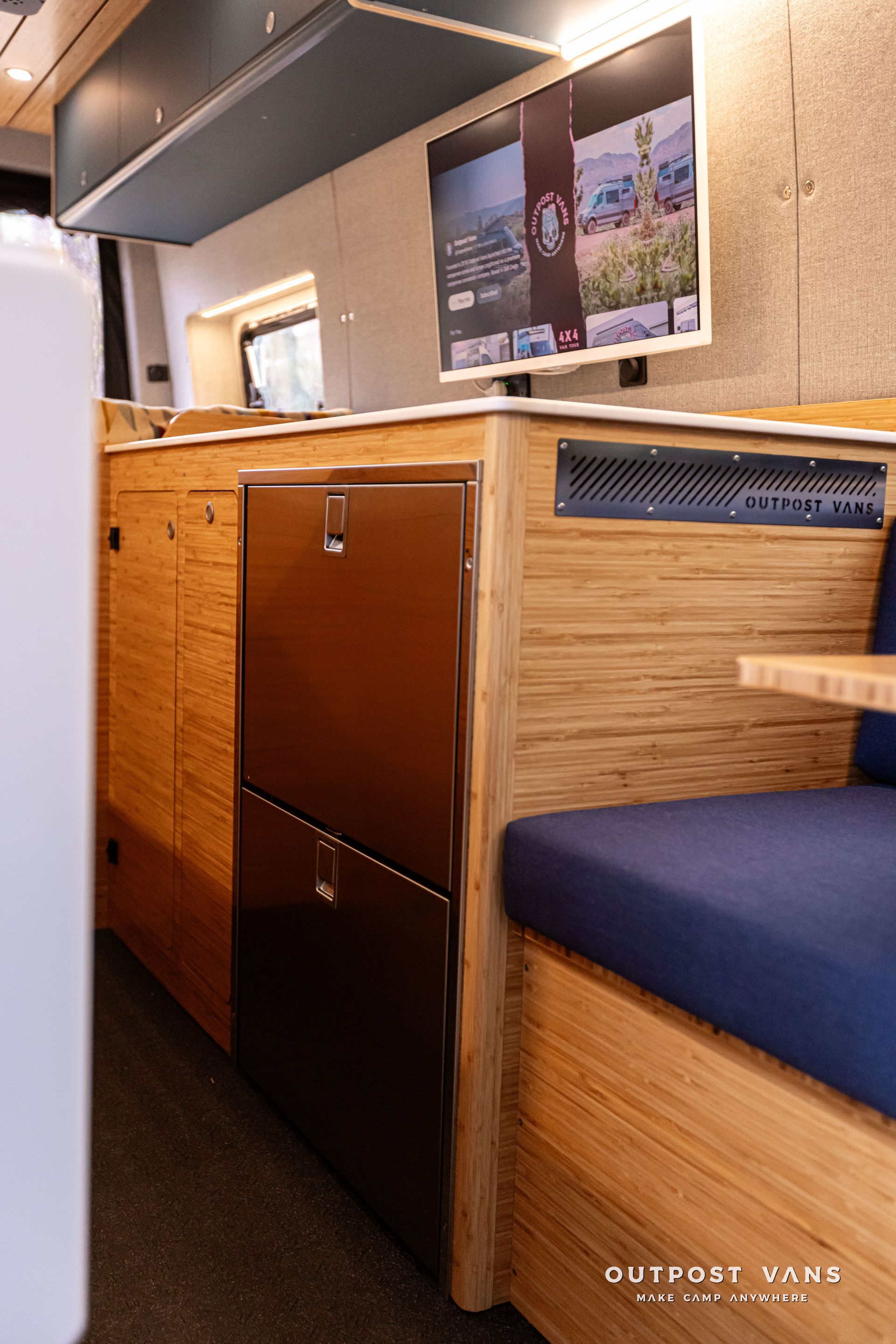 A kitchen in a camper van with a picture on the wall.