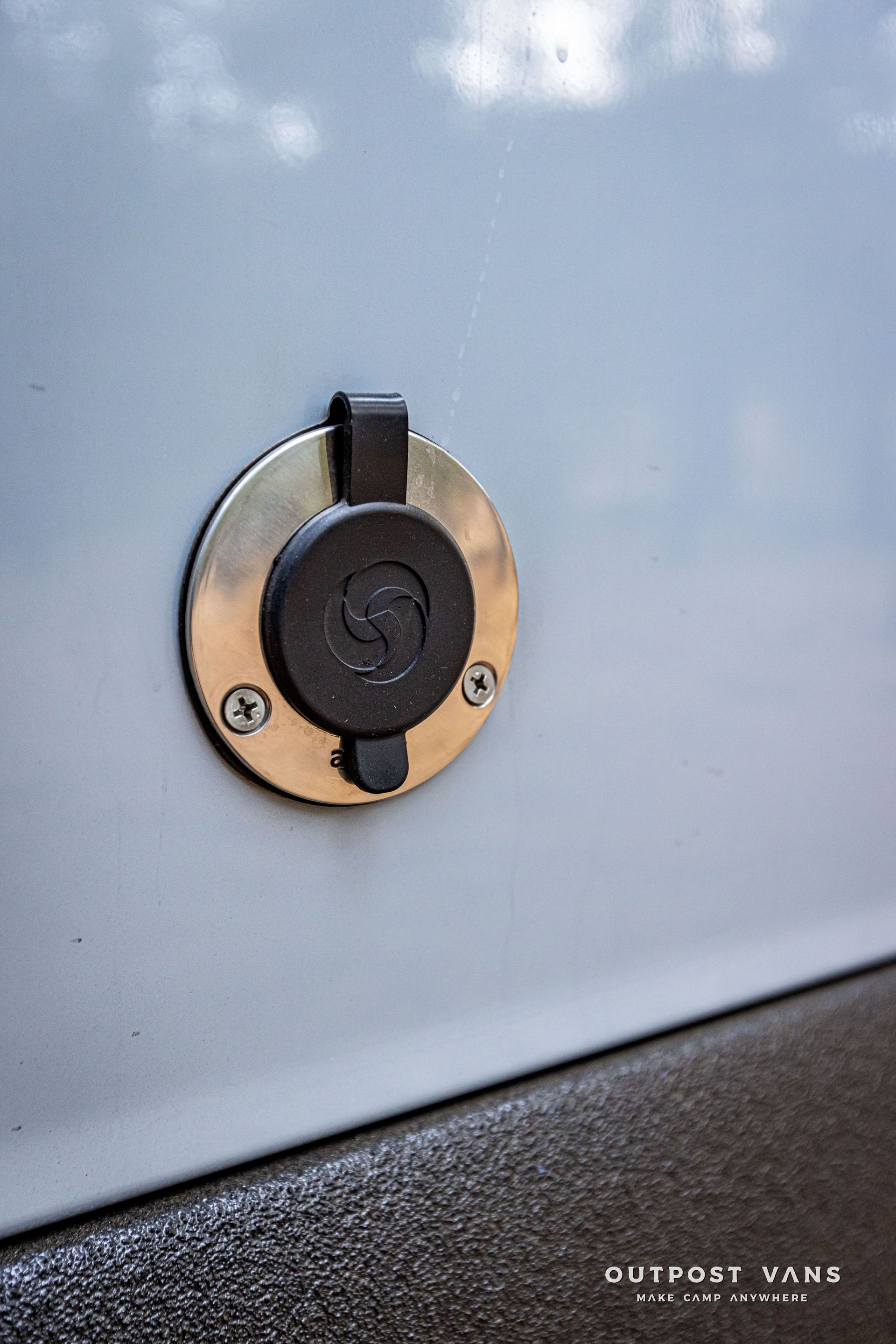 A close up of a power outlet on the side of a van.