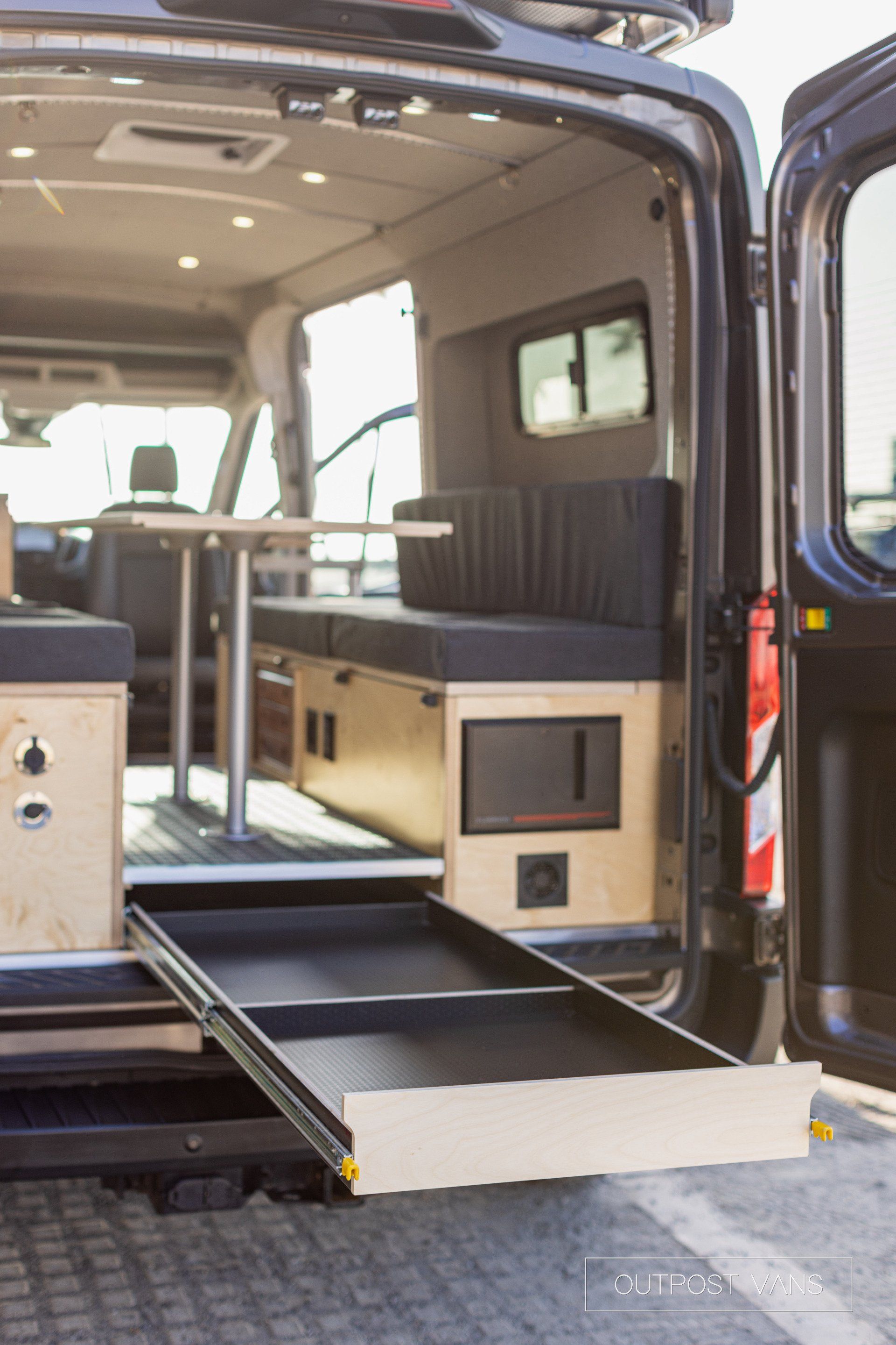 the back of a van with the door open and a drawer in the back .