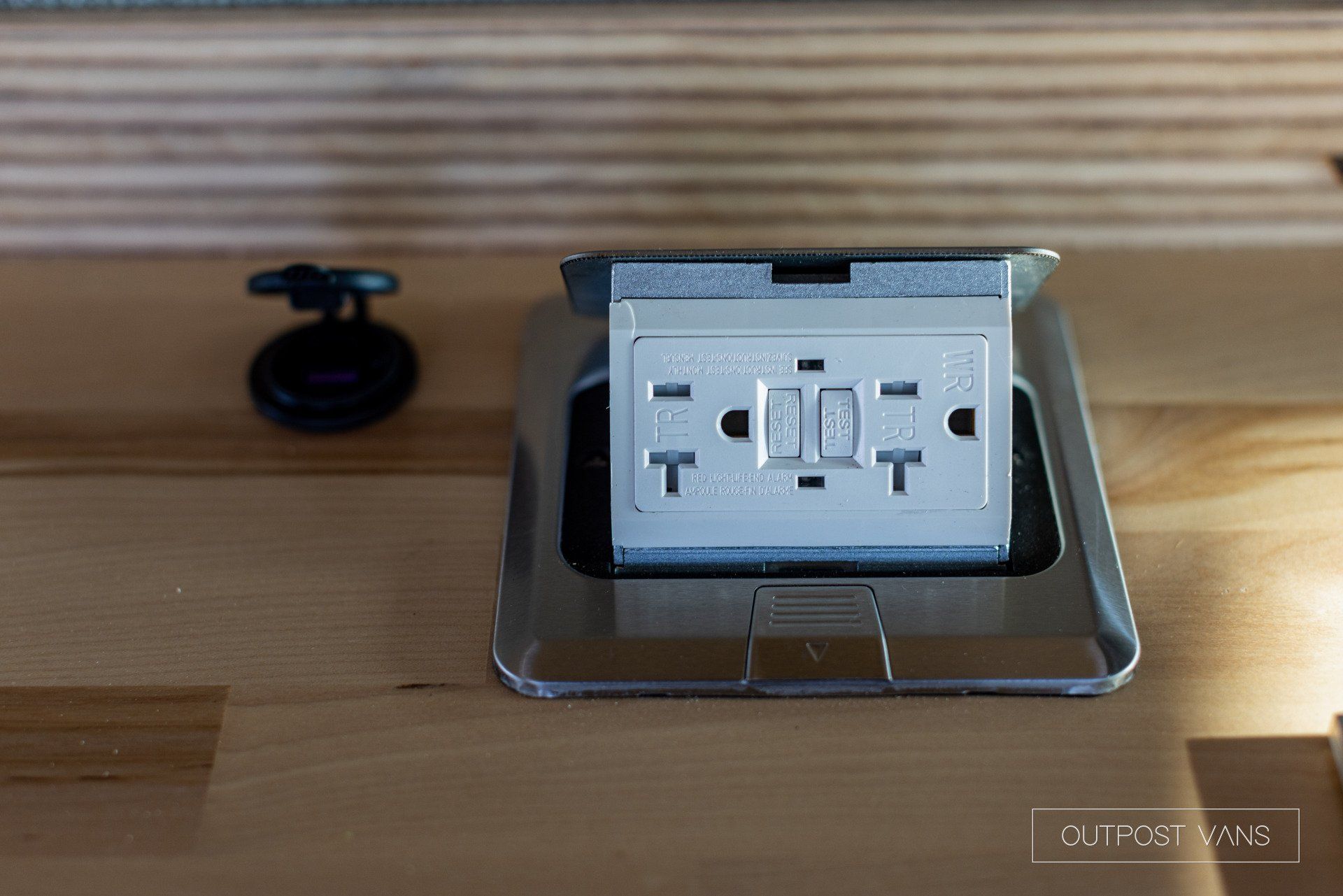 a white electrical outlet is sitting on a wooden table .