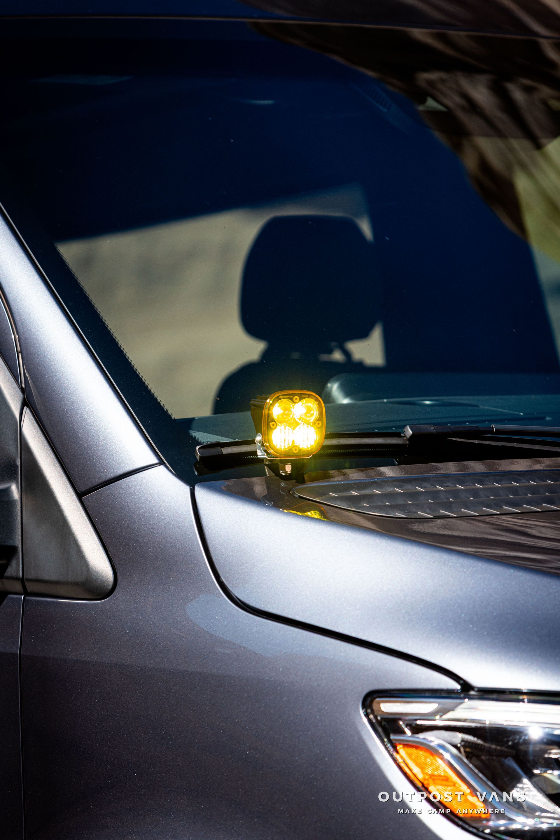 A close-up of a sprinter van hood with baja designs squadron ditch lights