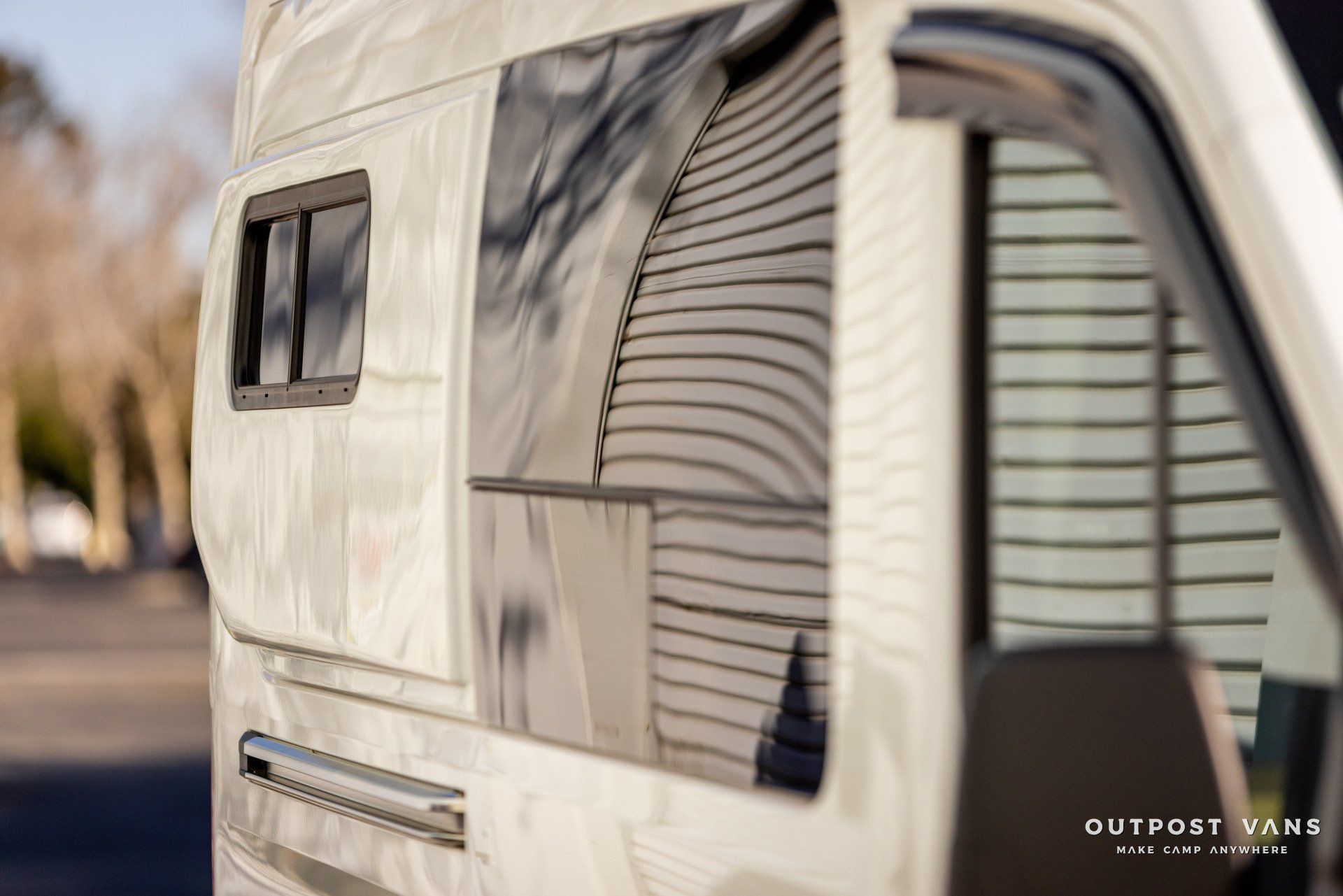 a white van with a window on the side of it is parked on the side of the road .