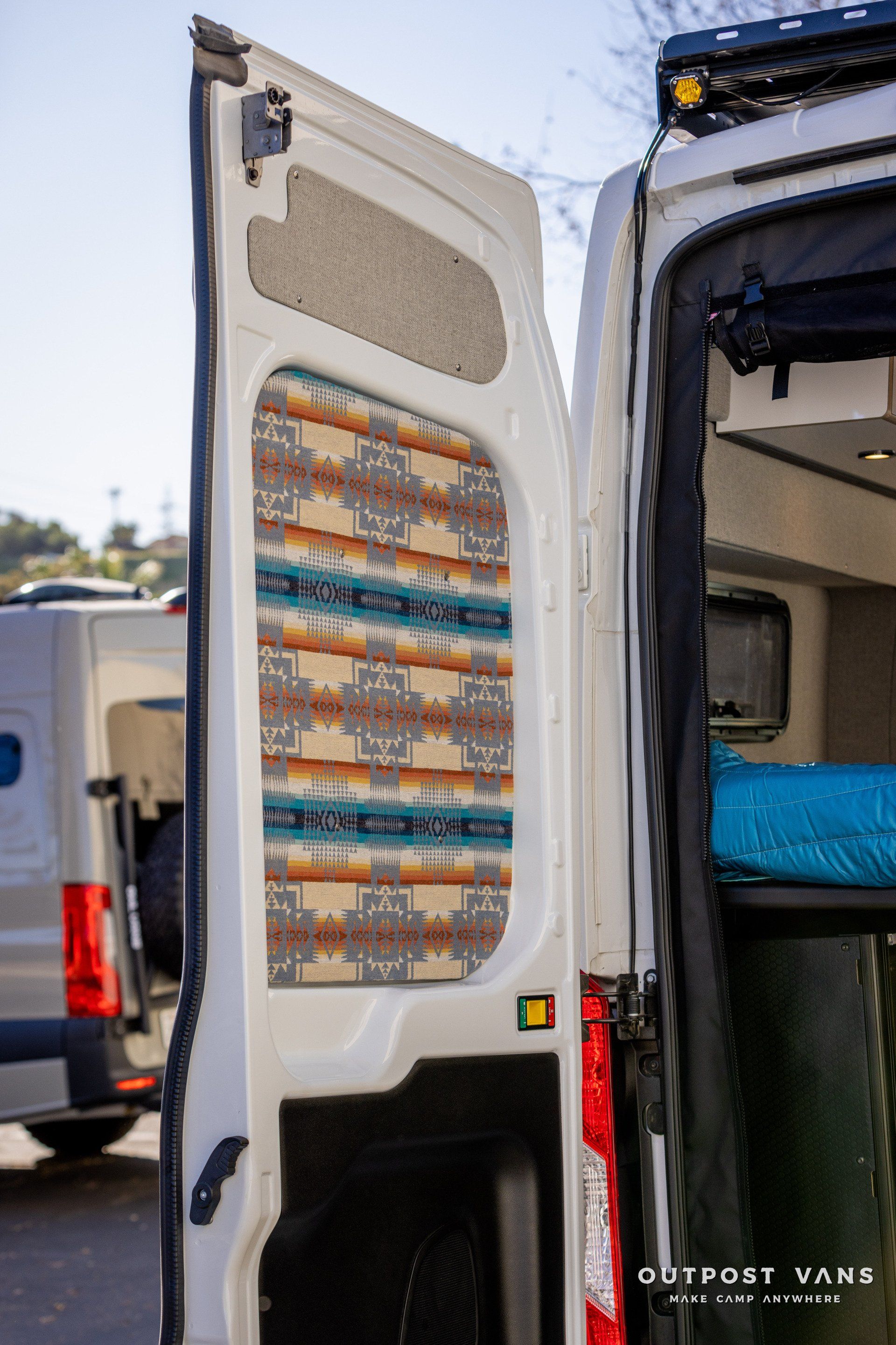 a white van with the door open is parked in a parking lot .