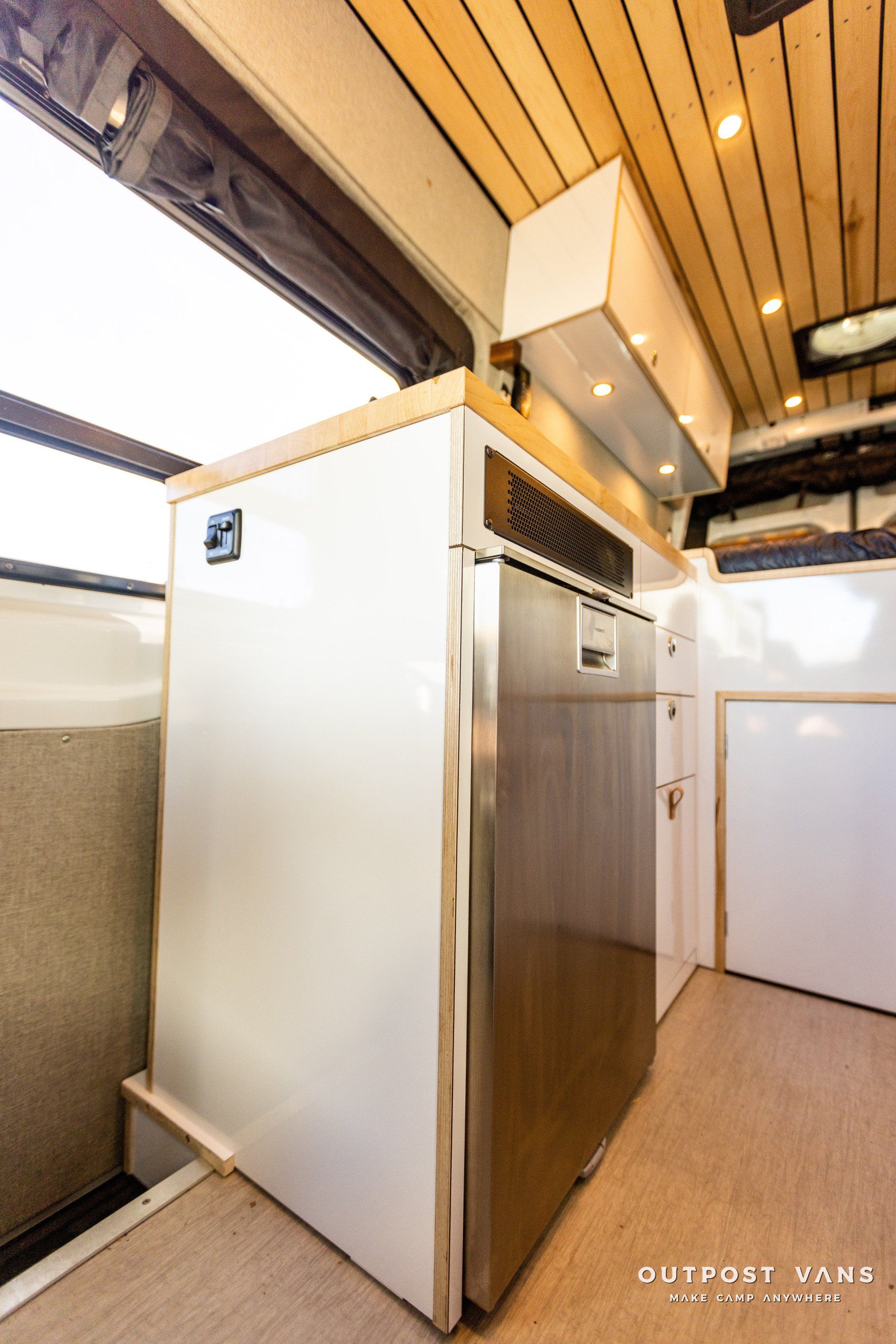 a stainless steel refrigerator is sitting in a kitchen next to a window .