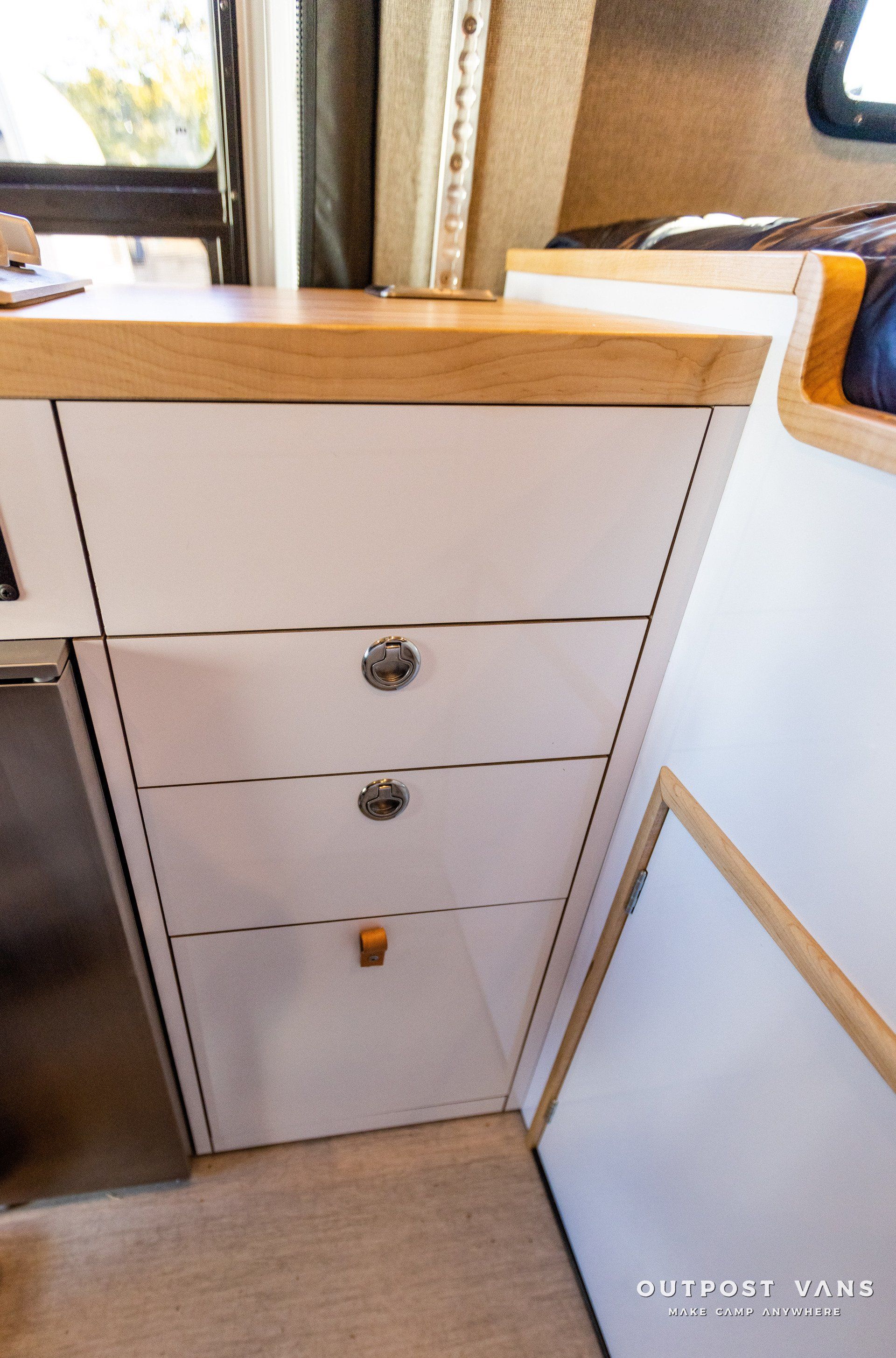 a dresser with three drawers and a wooden counter top in a kitchen .