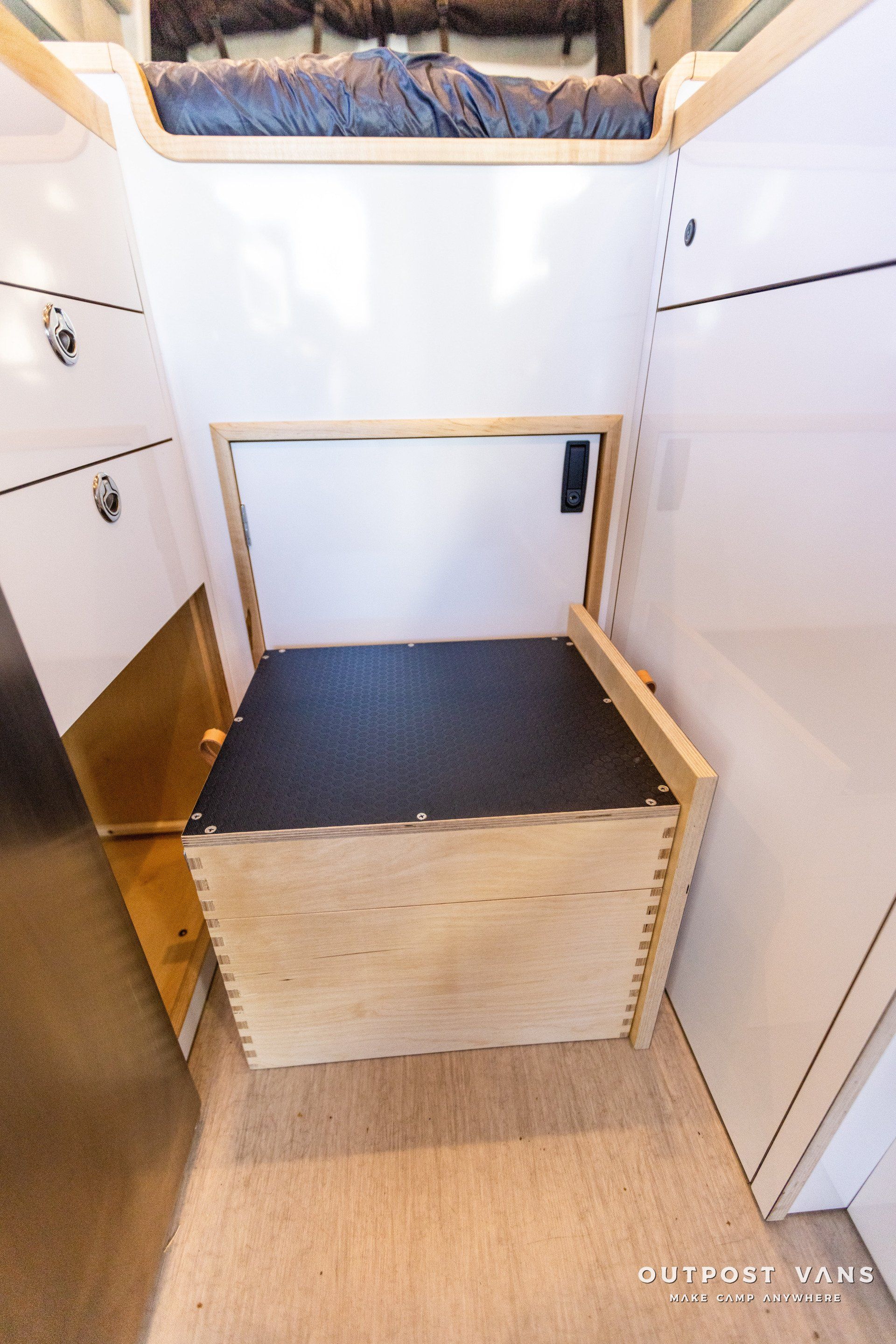 a wooden box is sitting in a room next to a bed .